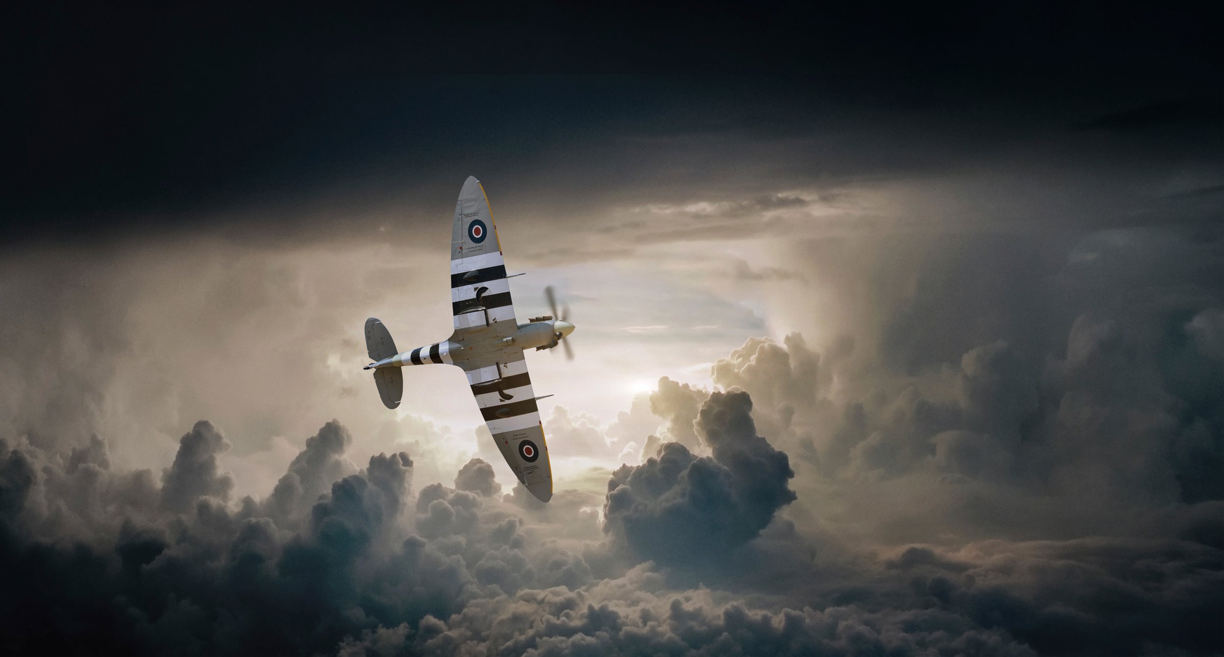 Spitfire flying through clouds with sun setting in background, Aviation photography, Tim Wallace.