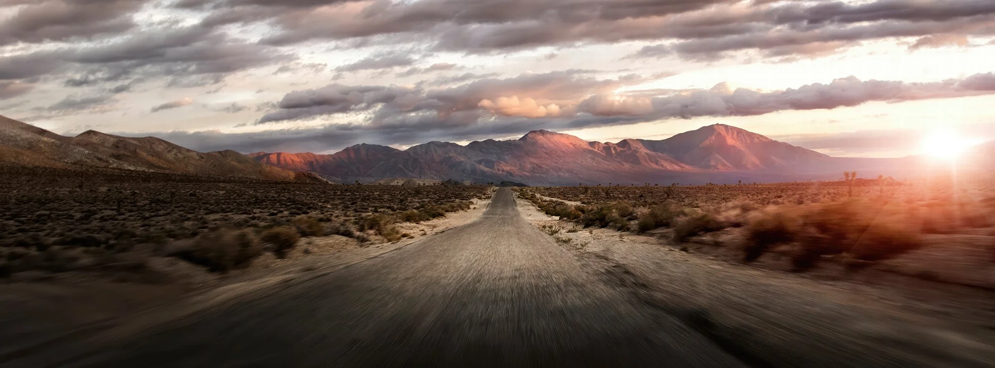 Dessert road into mountains as the sun sets