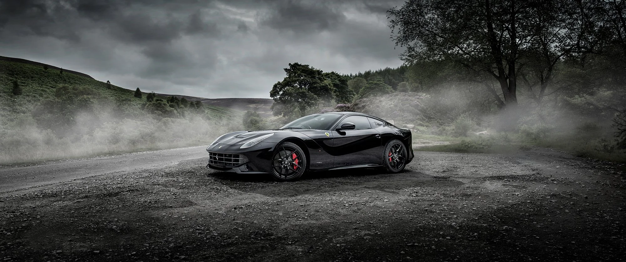 Ferrari in black colour on misty country road.