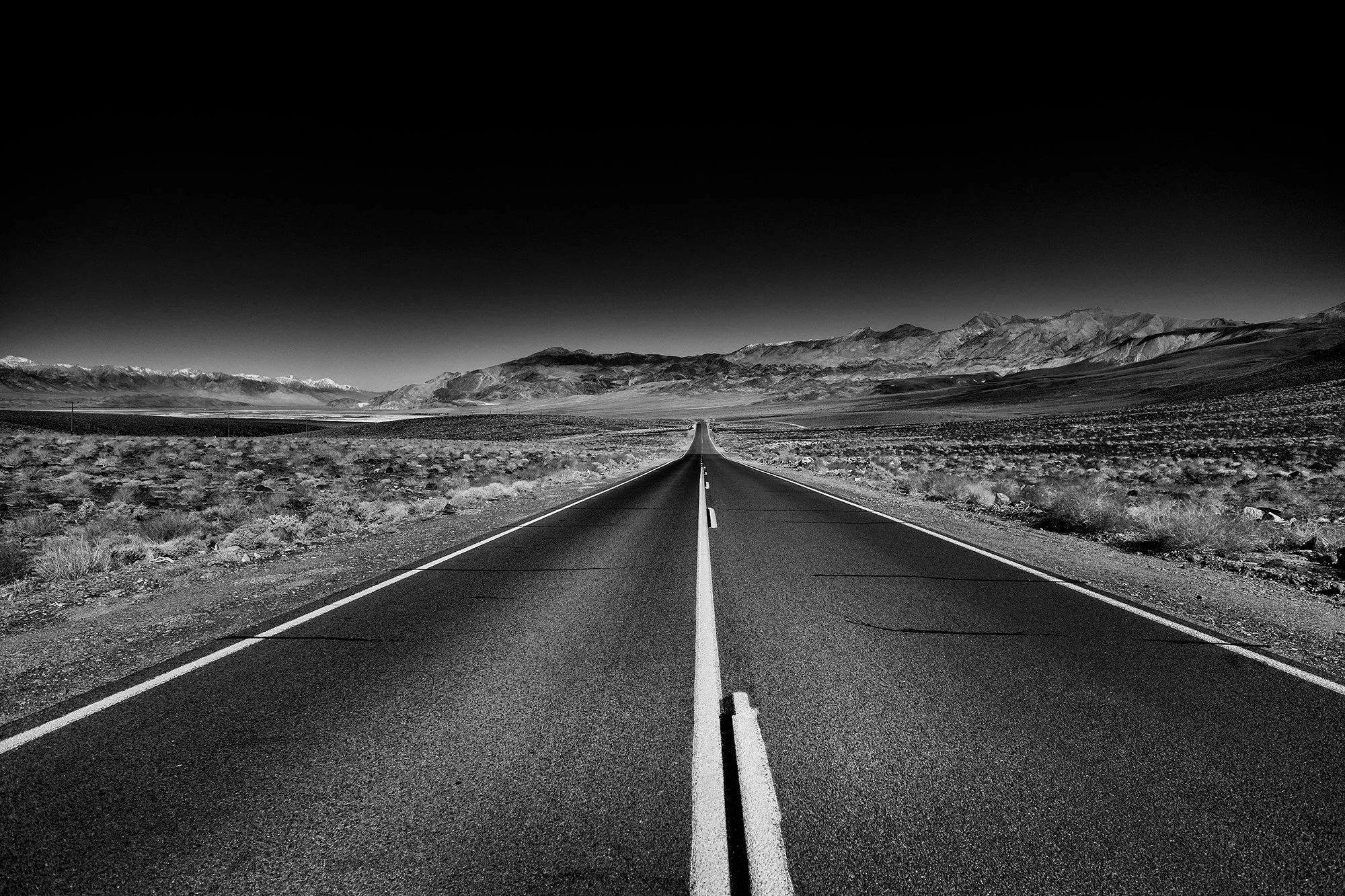 Death Valley desert road leading to mountains.