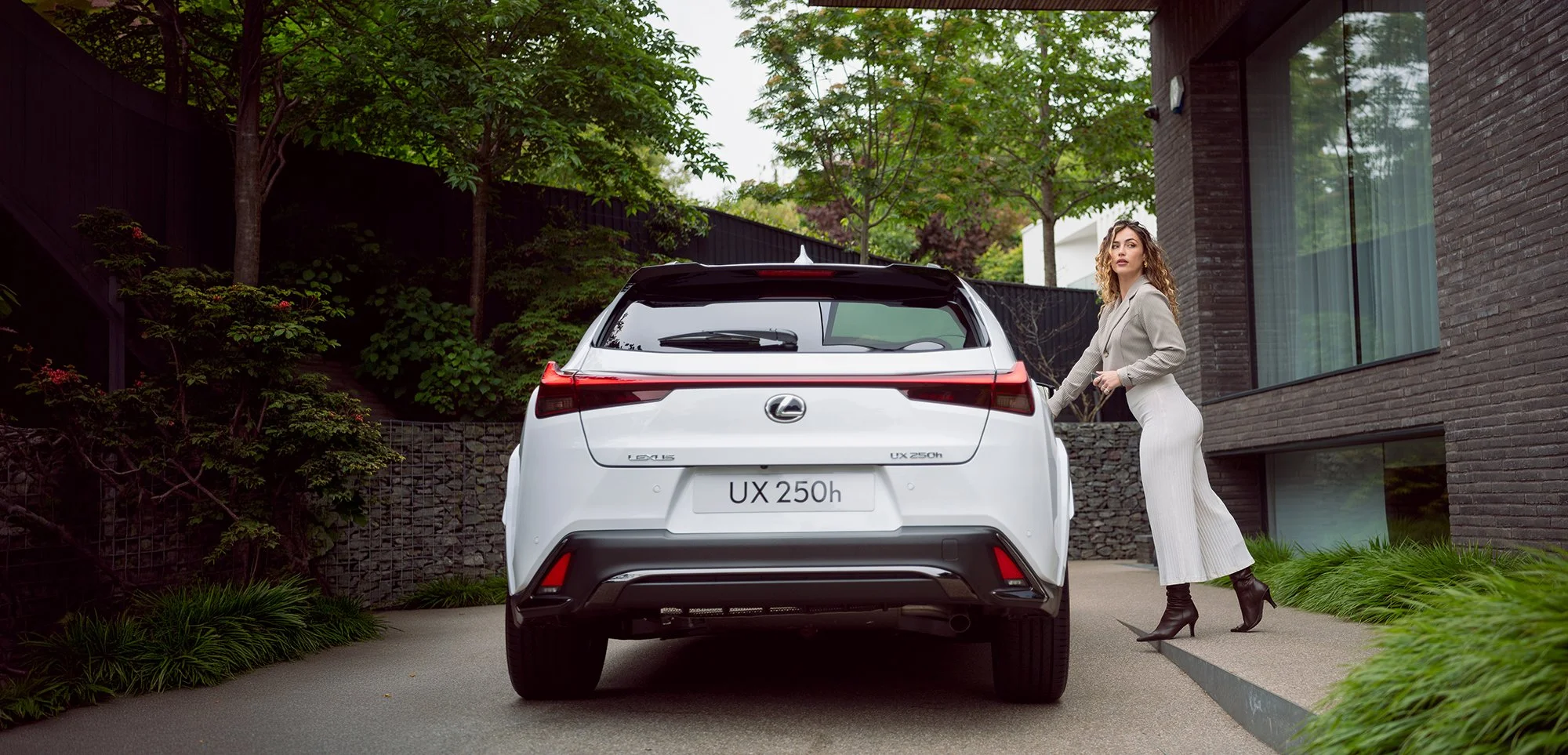 Woman opening door of white Lexus car.