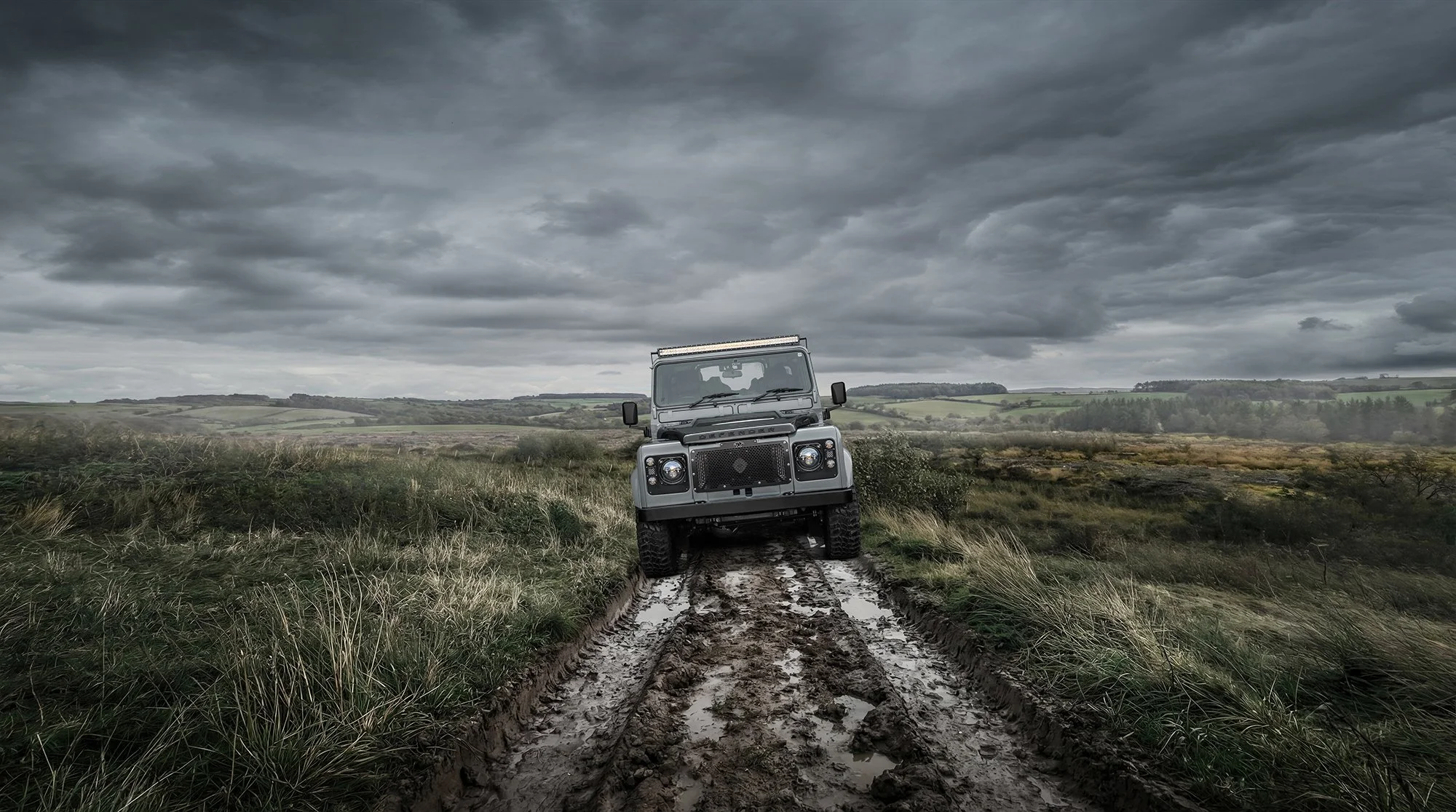 Land Rover Defender on muddy dirt track