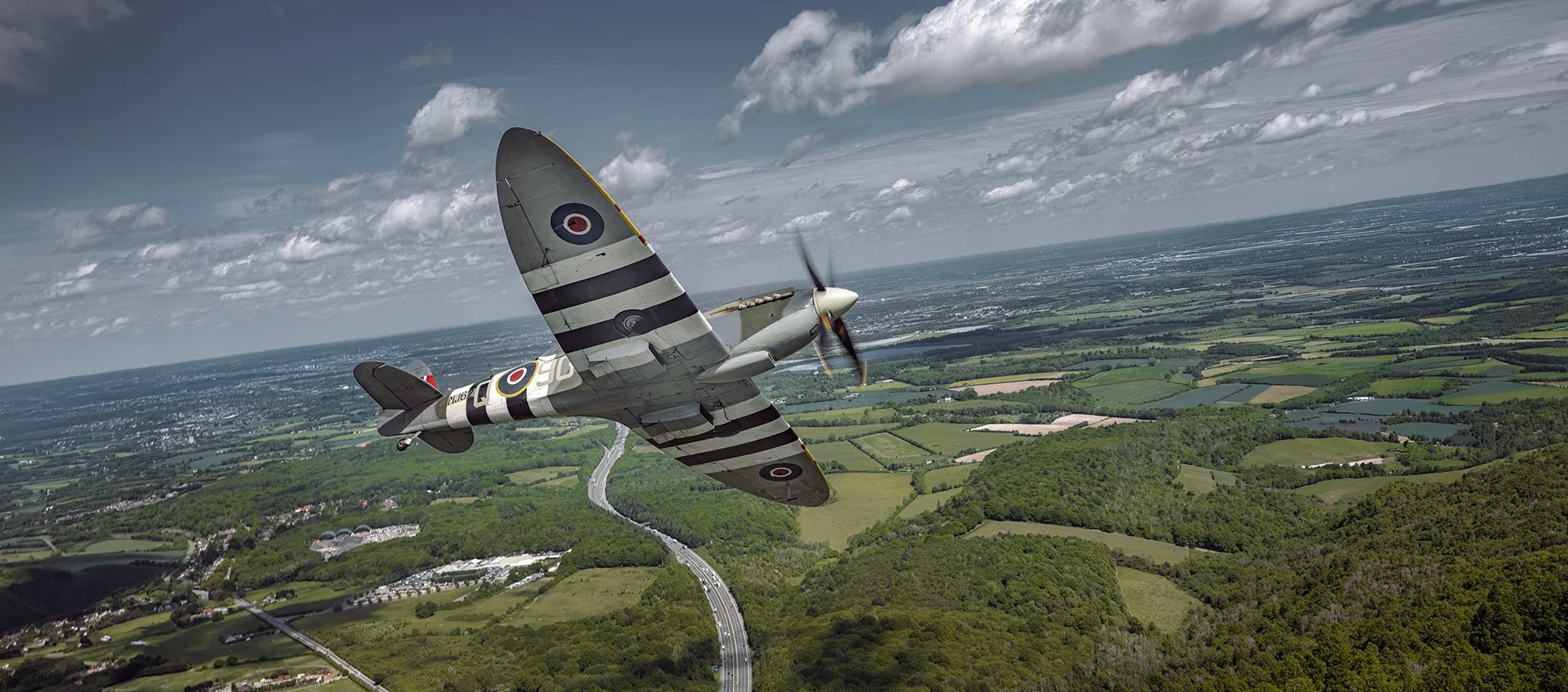 Spitfire in flight over English countryside.