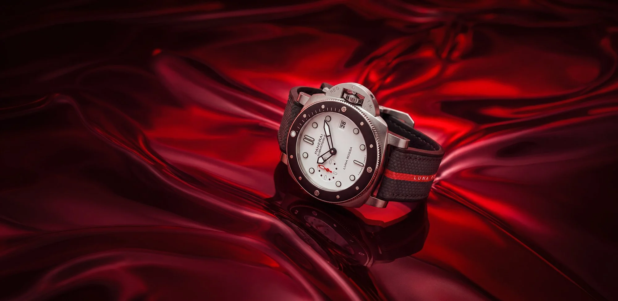Watch in front of background of red dramatic swirls of light.