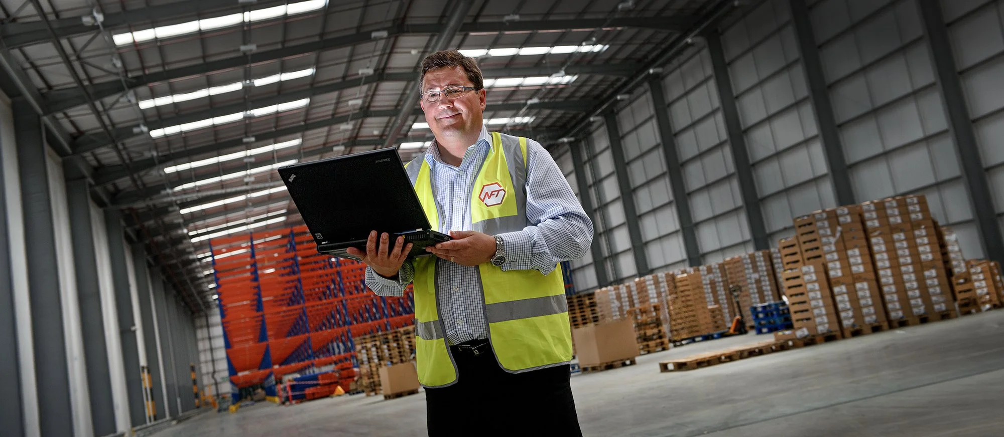 Warehouse worker in warehouse with a laptop