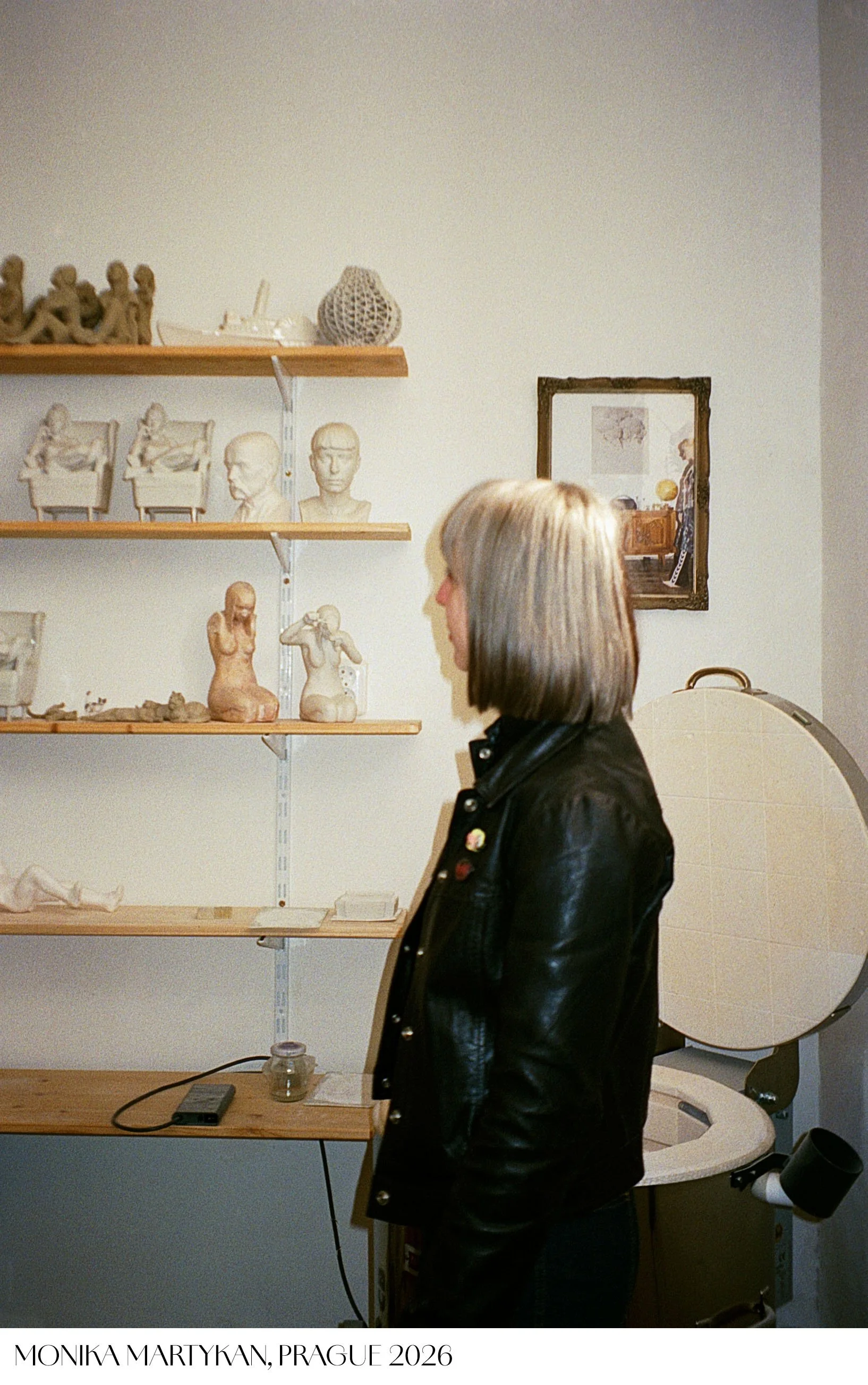 Young artist Monika Martykan looking at her sculptures on a shelf in her studio in Prague. Analog flash photography by Tereza Konarikova See you in a good light 