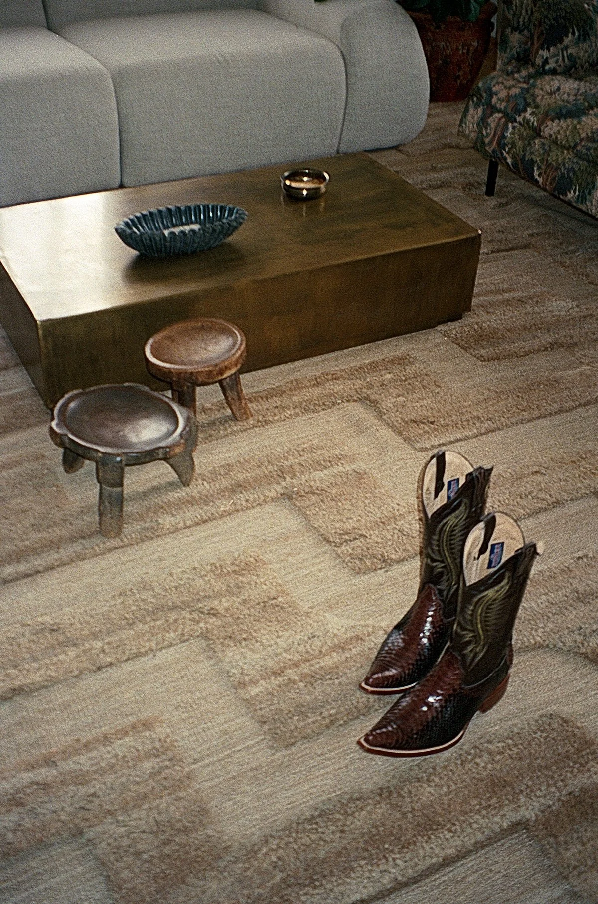 Analog interior photography of cowboy boots with Wolke sofa and a coffee table by Westwing