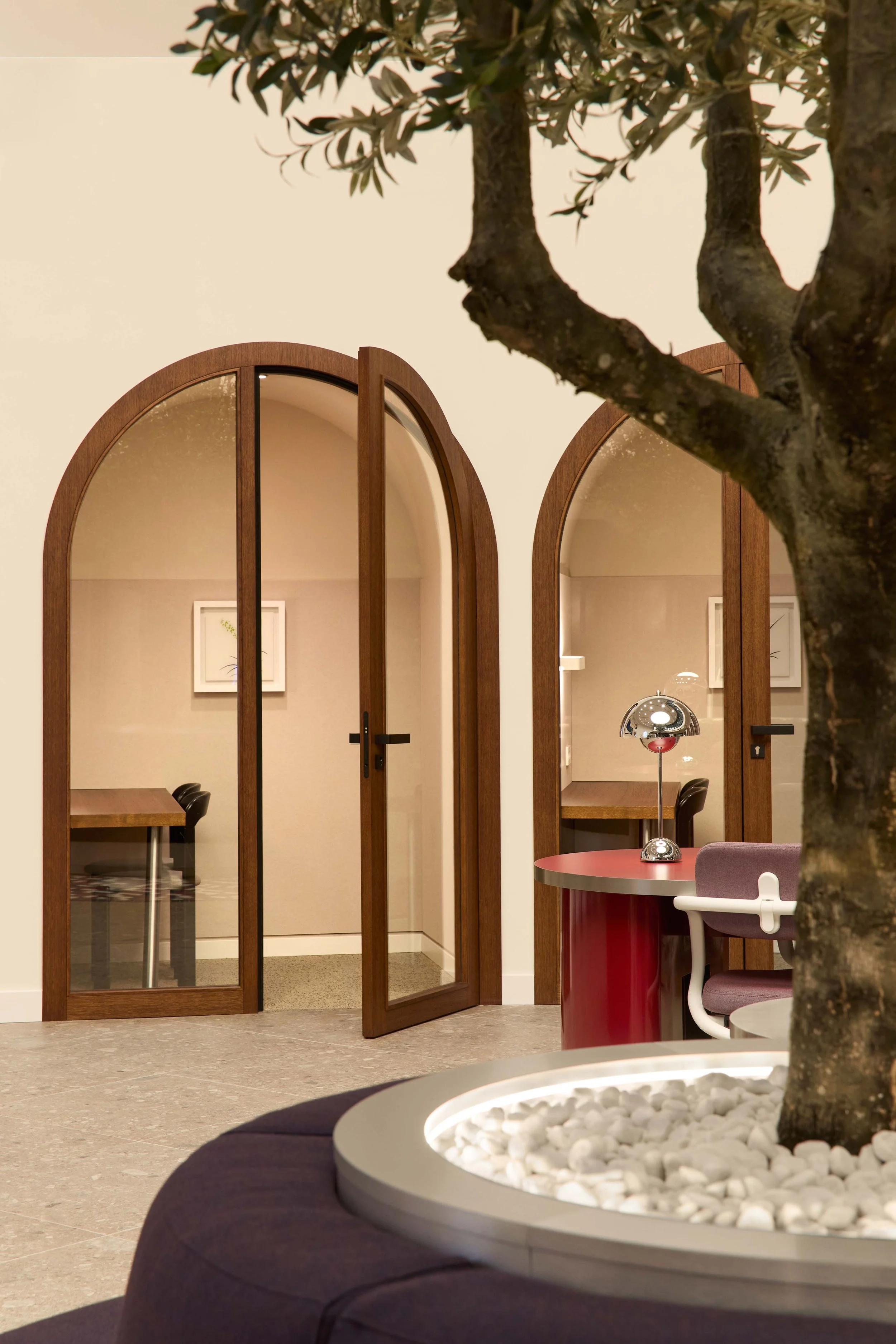Soundproof call booth at WeWork in Munich, Germany, indoor tree softly visible in the foreground, photographed by Tereza Konarikova.