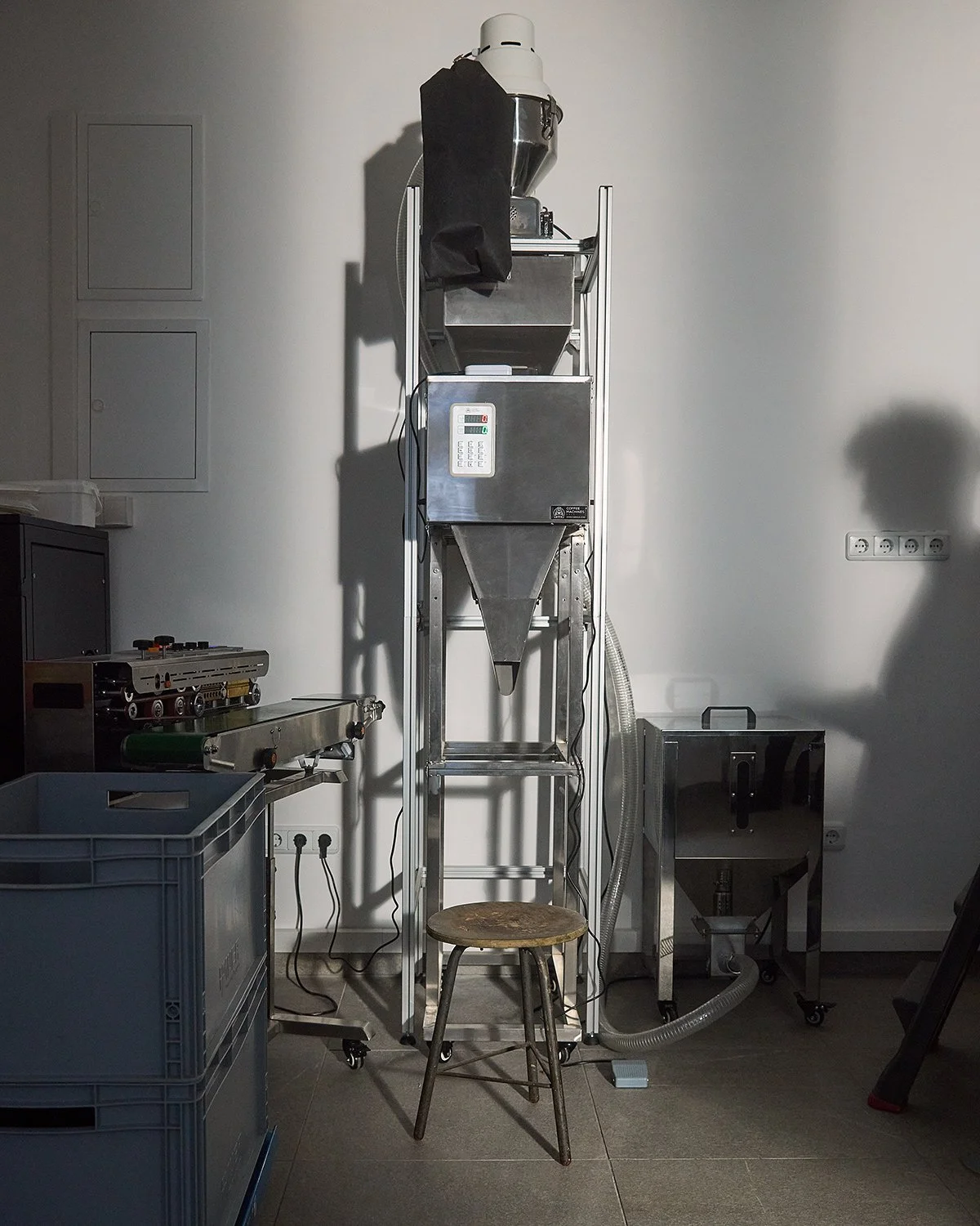 Coffee roasters interior enlighten with sunlight with a men shadow on a wall photographed by Tereza Konarikova