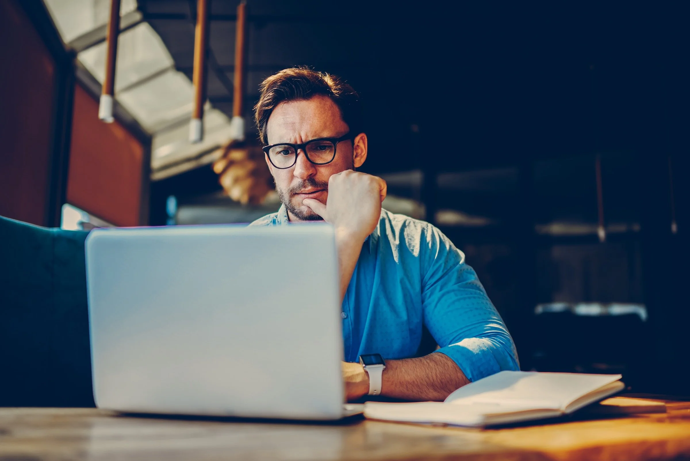 Executive frustrated looking at his laptop sitting at a table