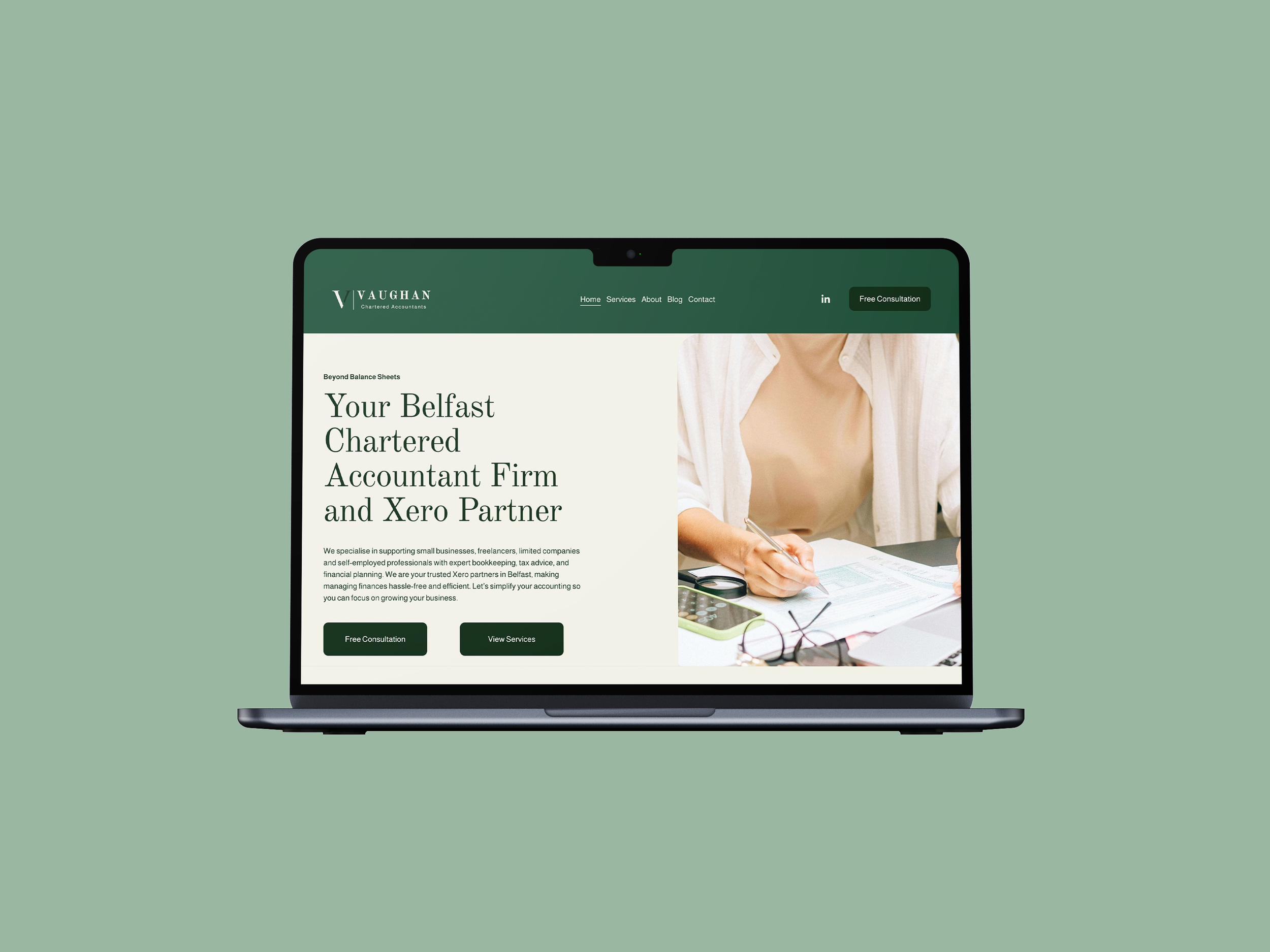 Laptop displaying a website for a Belfast-based chartered accountant firm with green and white colors and a photo of a person writing documents.
