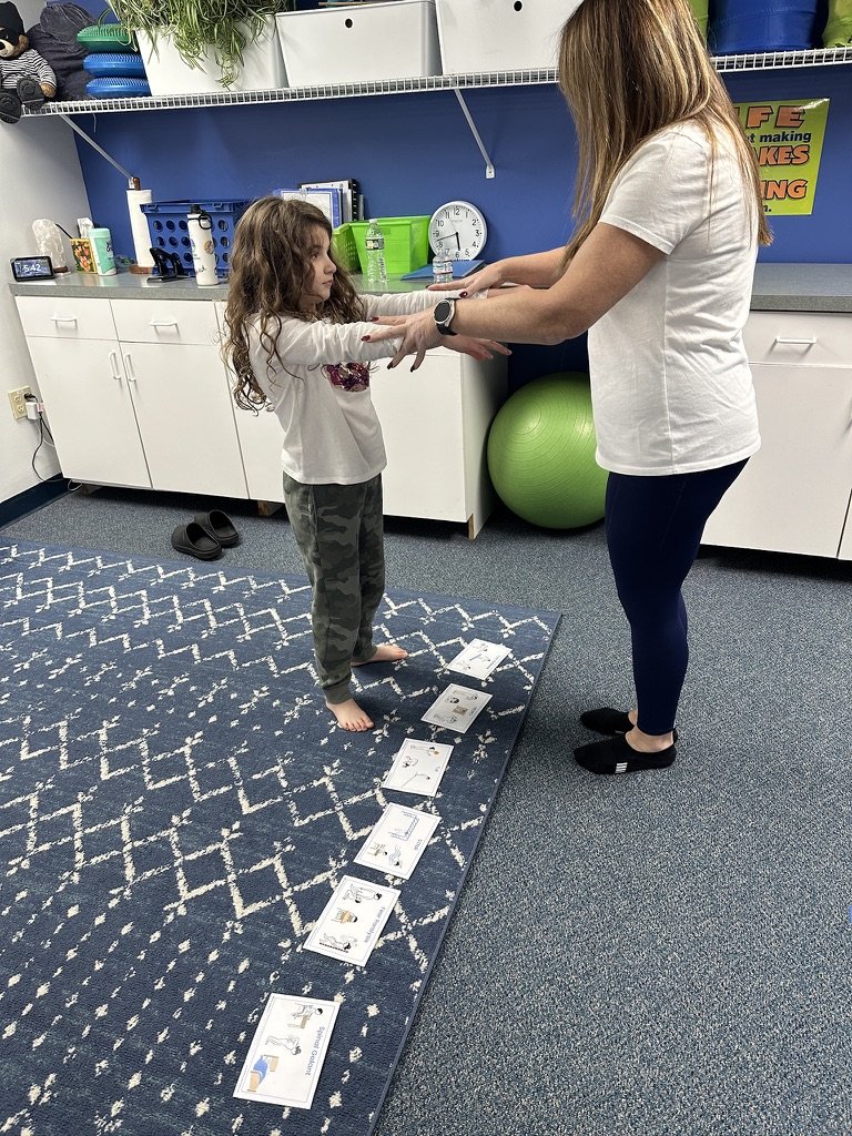 Child using 'muscle checking' with program facilitator to identify the reflex to work on that day