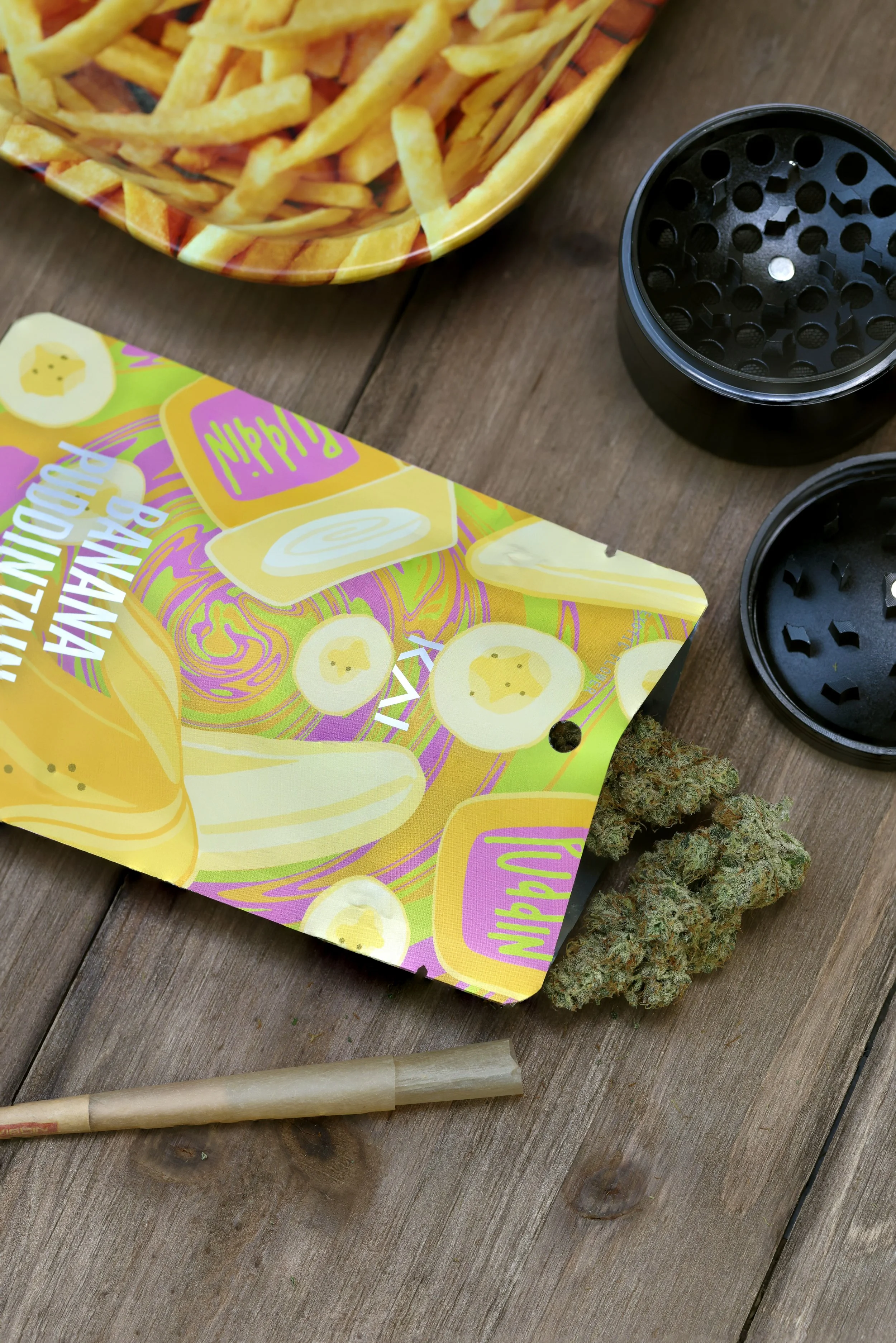KAI Cultivation 3.5G Pre-Pack of Banana Puddintain cannabis with buds spilling out, a variety of rolling papers, and black grinder.