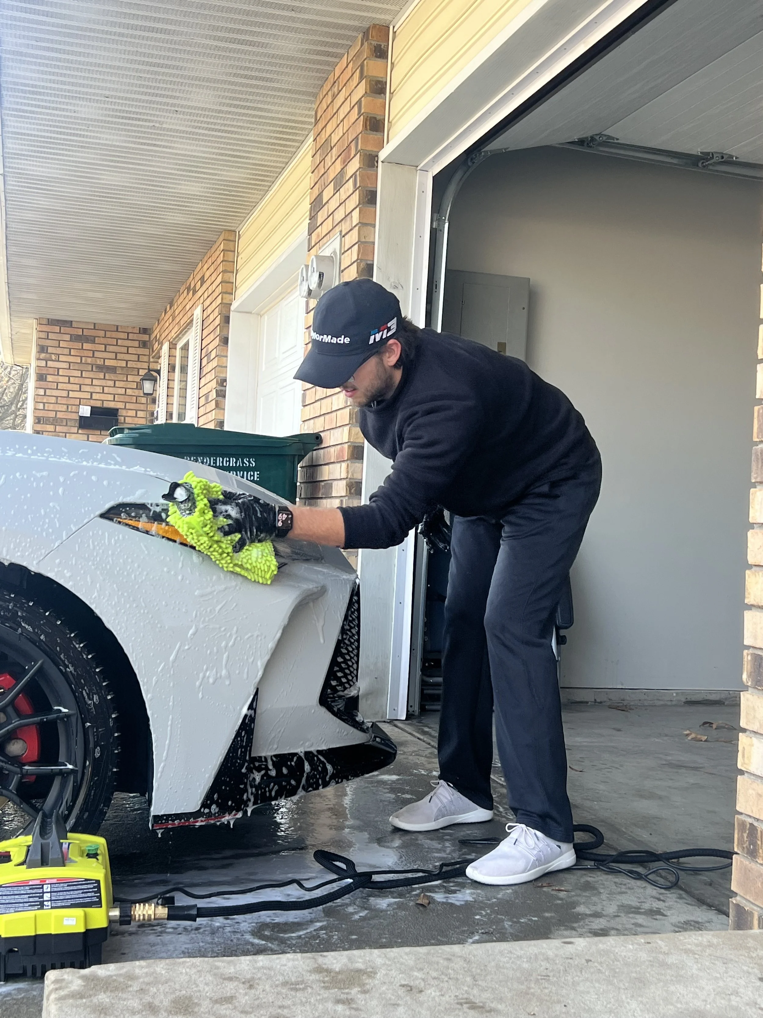 Someone washing a soapy car with a microfiber wash mitt