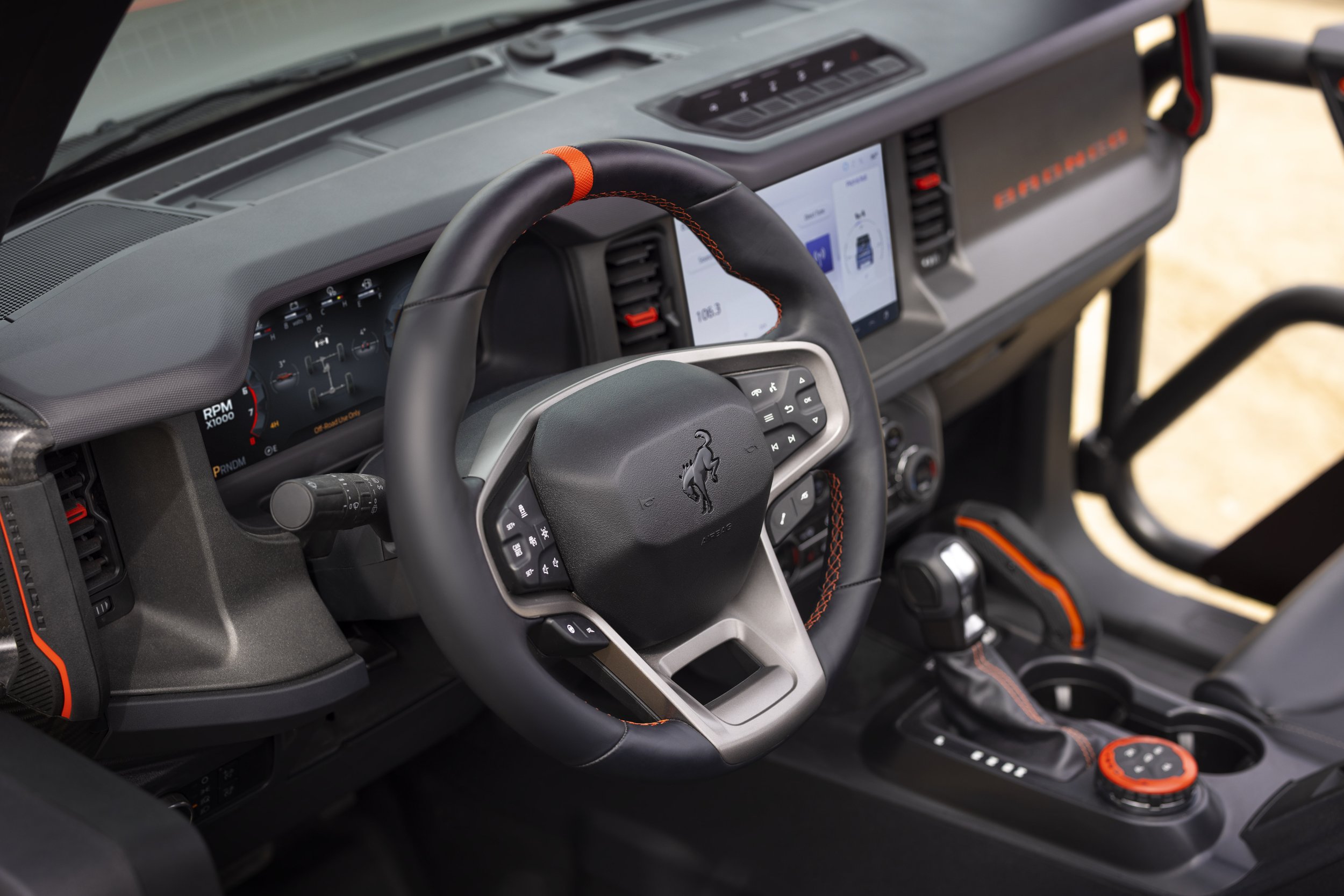 Interior details showing the steering wheel and Code Orange color keyed stitching, grip handles, and G.O.A.T. bezel.