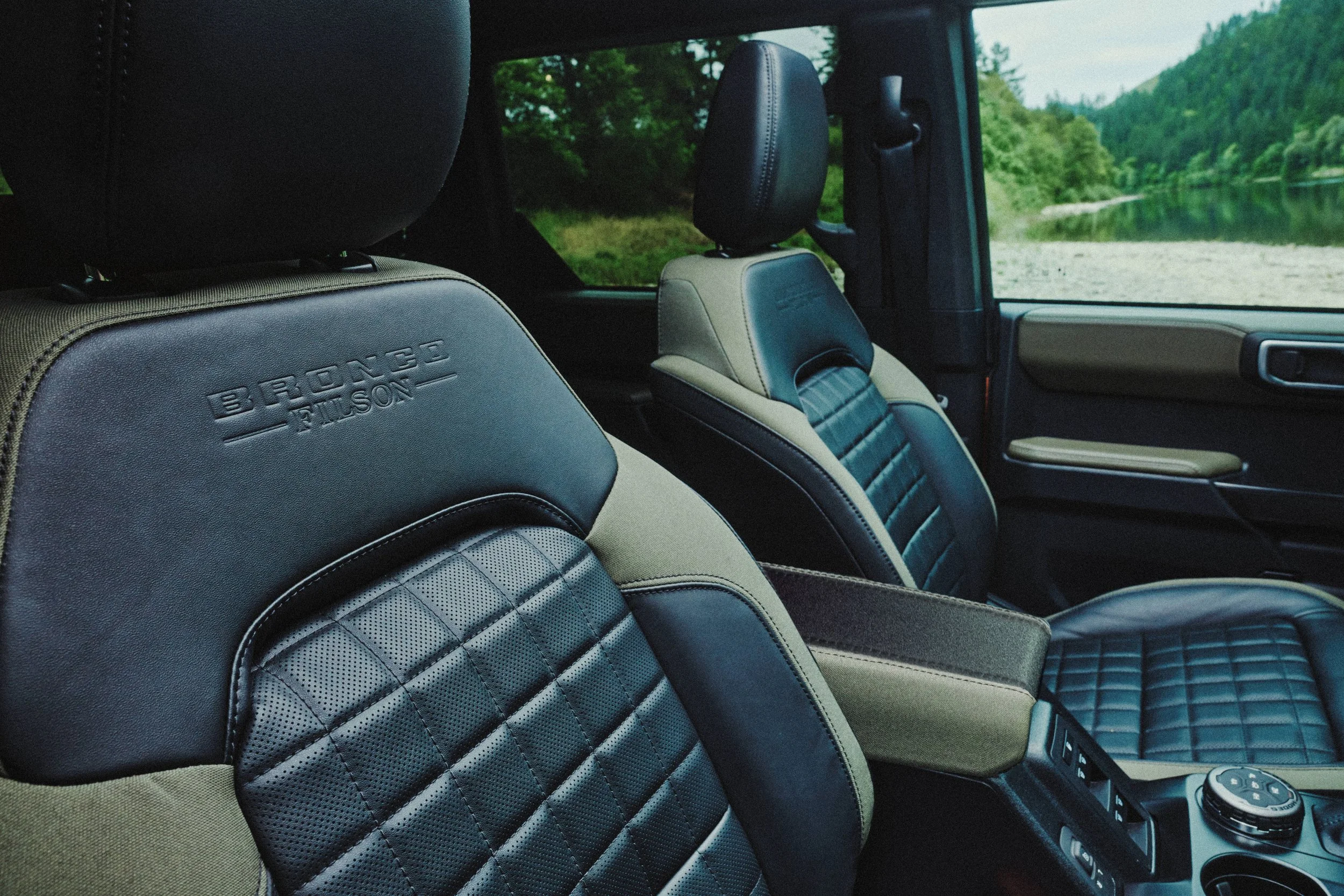A detail of the interior of the 2027 Bronco Filson Edition showing the debossed branding on the shoulder panel and quilted seating cushion inserts.