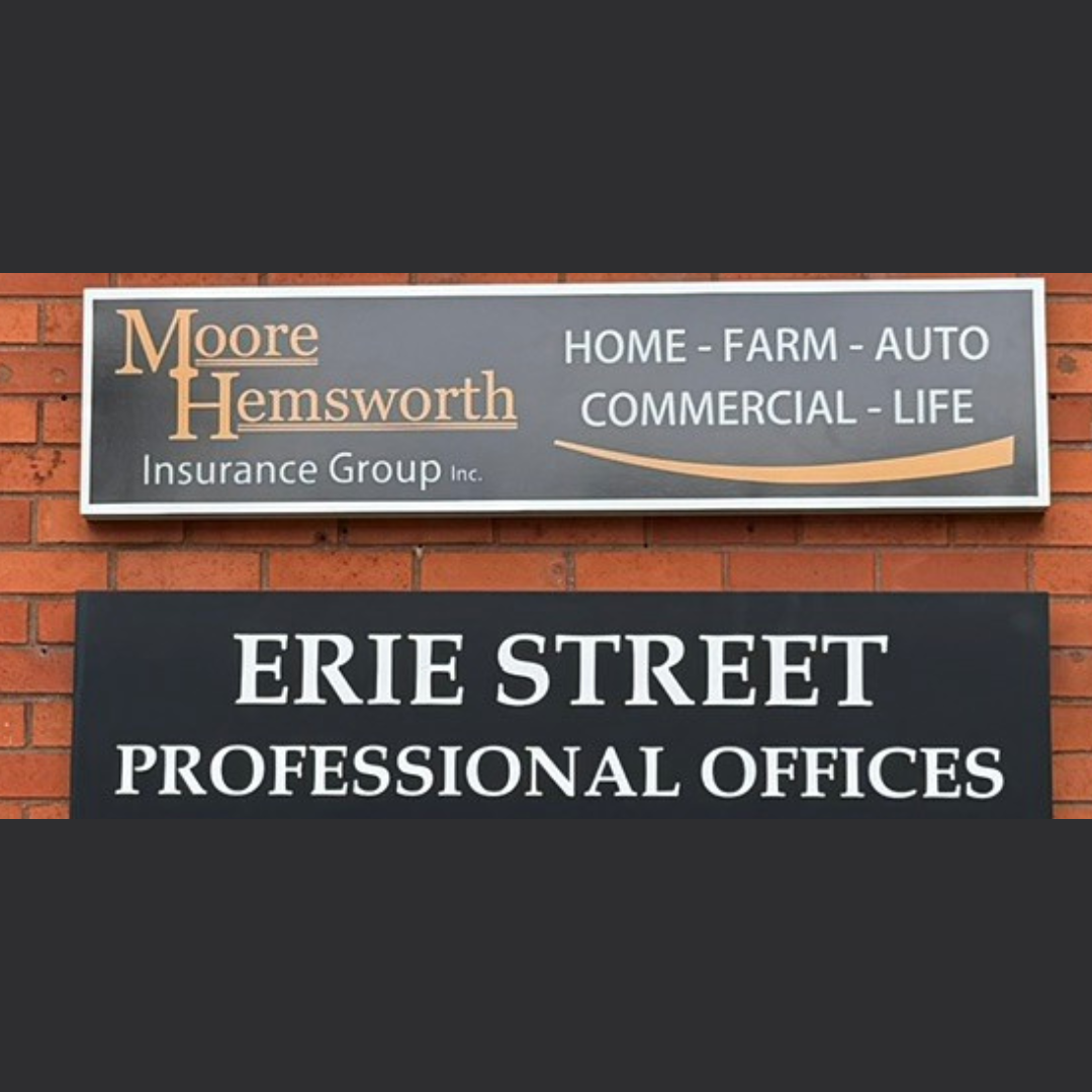 A storefront sign for Moore Hemsworth Insurance Group on brick wall of a building.