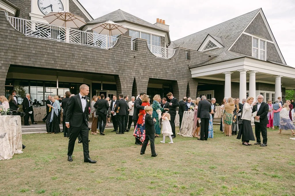 Guests mingling during cocktail hour on the lawn outside a Kiawah Island clubhouse wedding venue.