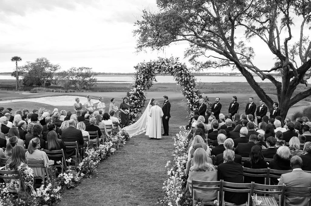 Kiawah Island wedding ceremony overlooking the water with floral aisle details and oak trees.