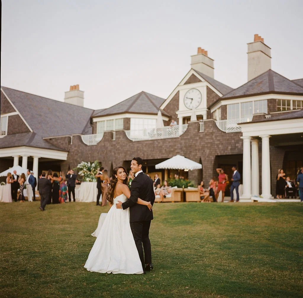 Newlywed couple standing on the lawn outside a coastal Kiawah Island wedding venue during their evening reception.