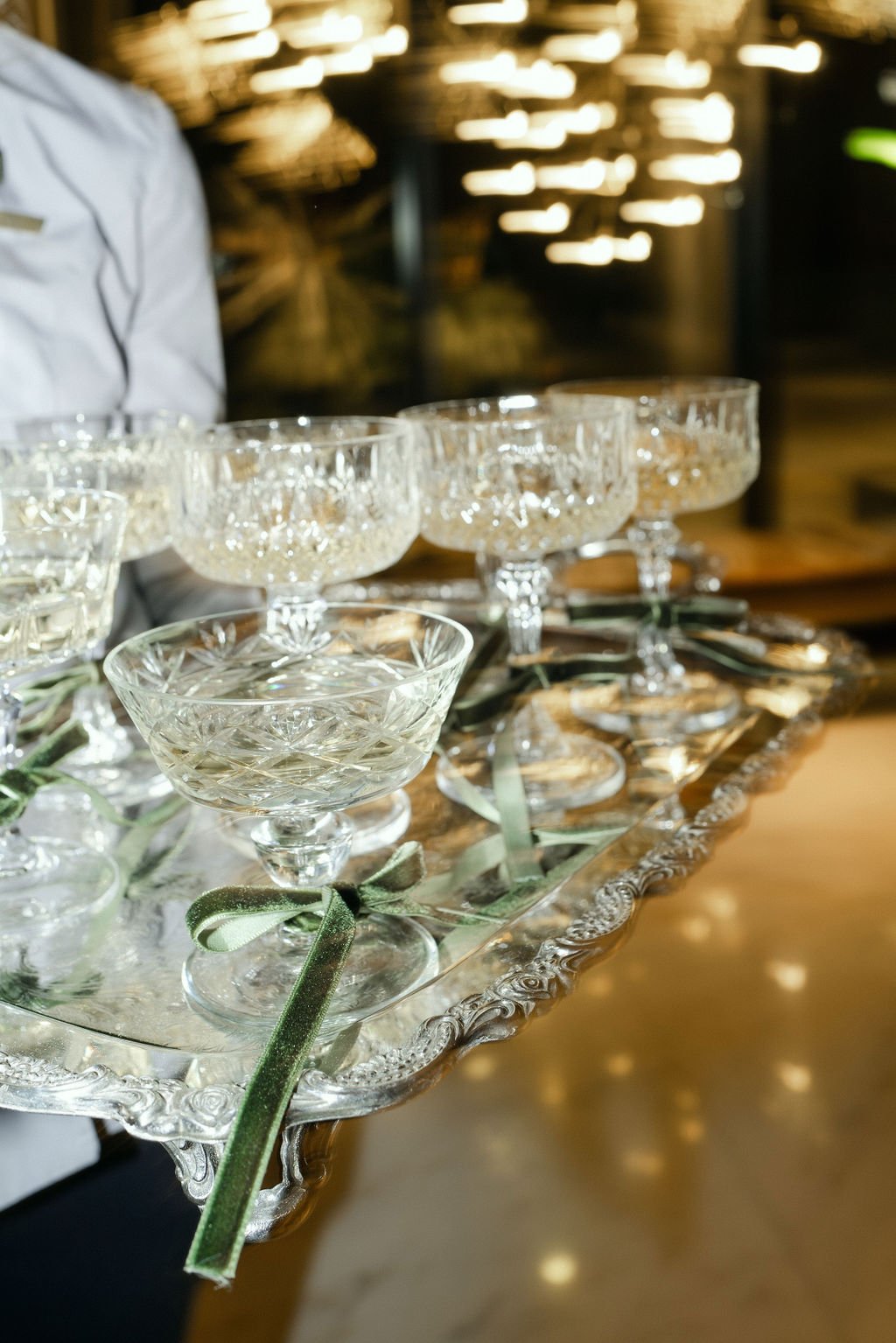 Crystal champagne glasses on a silver tray, tied with green ribbons, ready for a luxurious toast.
Anne Rhett Photography
The Dewberry Hotel
Emerson James Rentals
Charleston, South Carolina