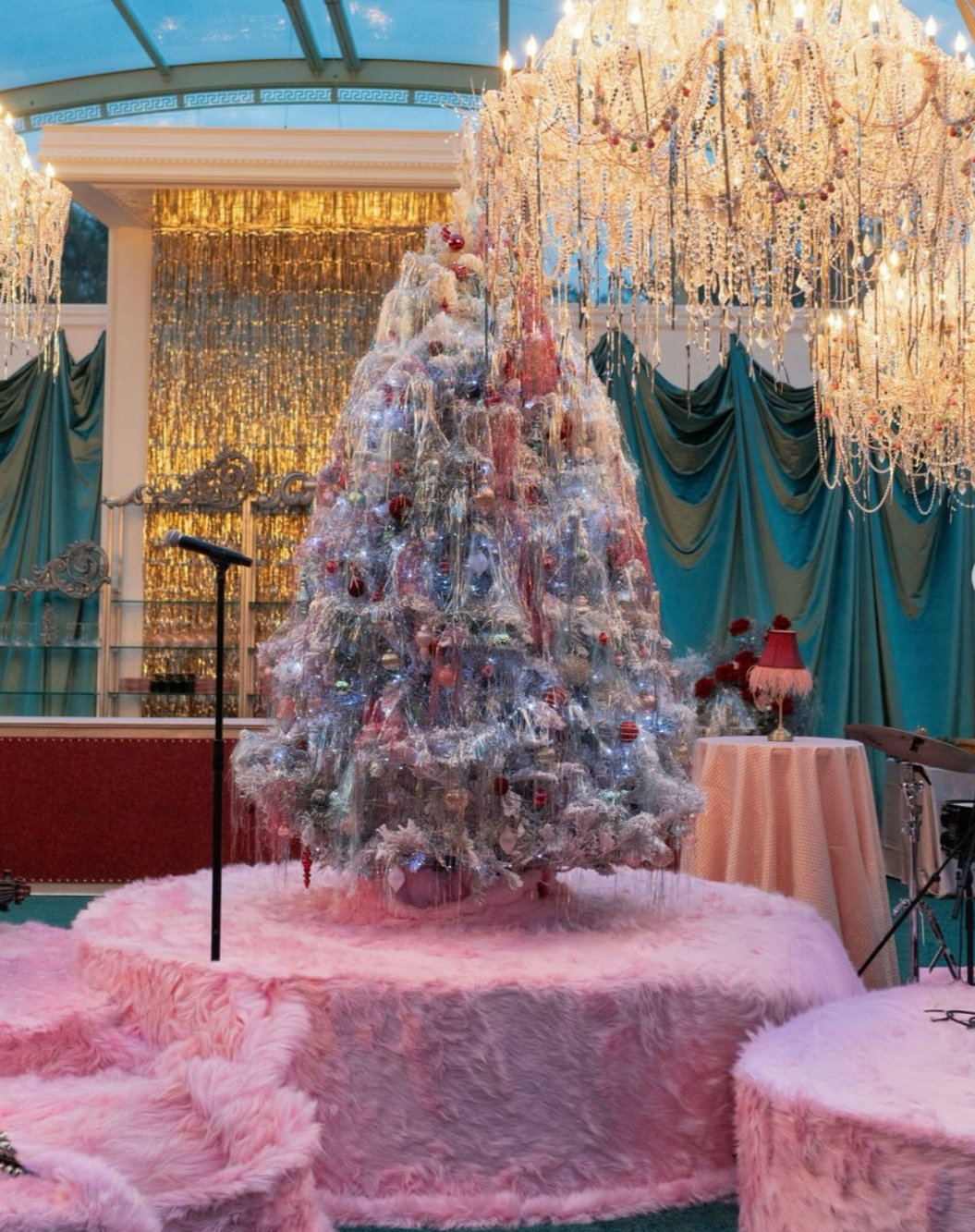 Immersive holiday event installation featuring a sculptural Christmas tree, chandeliers, and layered textures designed to evoke nostalgia and surprise