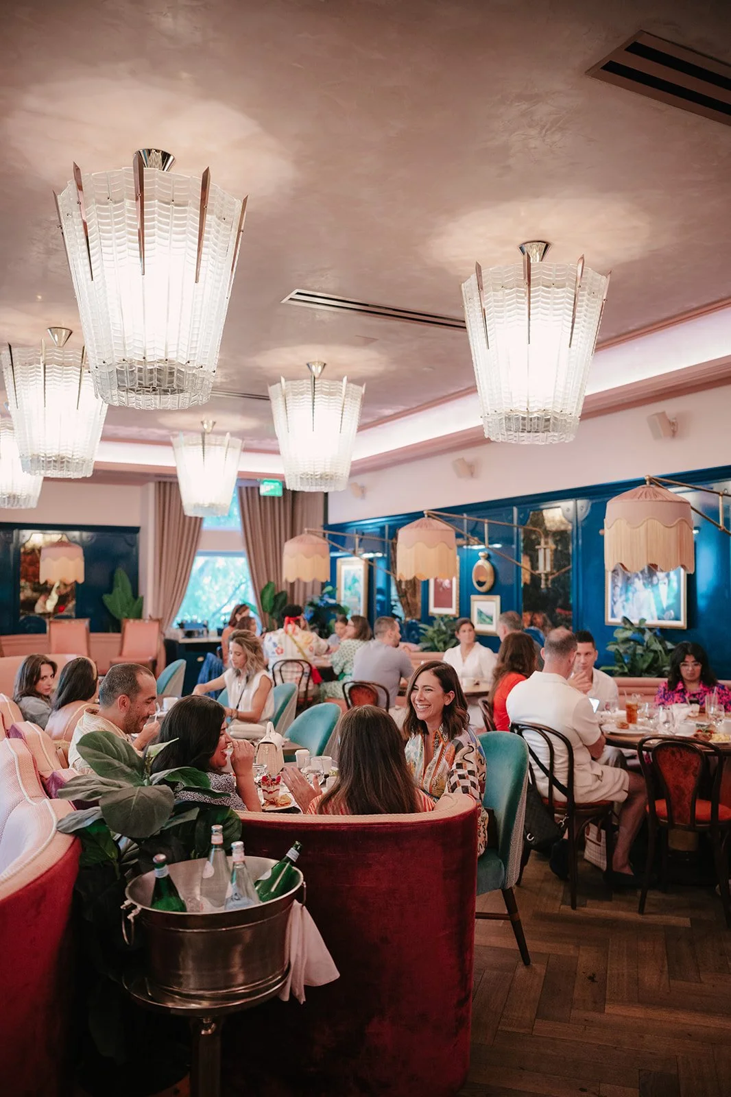 Guests gathered for a Freeda Network event in a colorful restaurant with pink seating, sculptural lighting, and a lively hospitality setting.