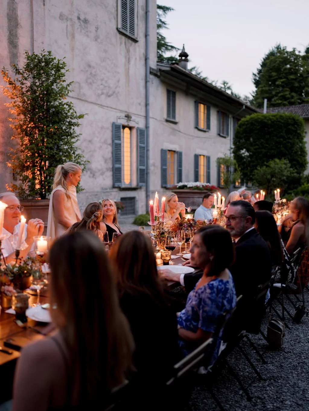 Guests gathered for a candlelit outdoor dinner at an Italian villa during a destination wedding weekend.