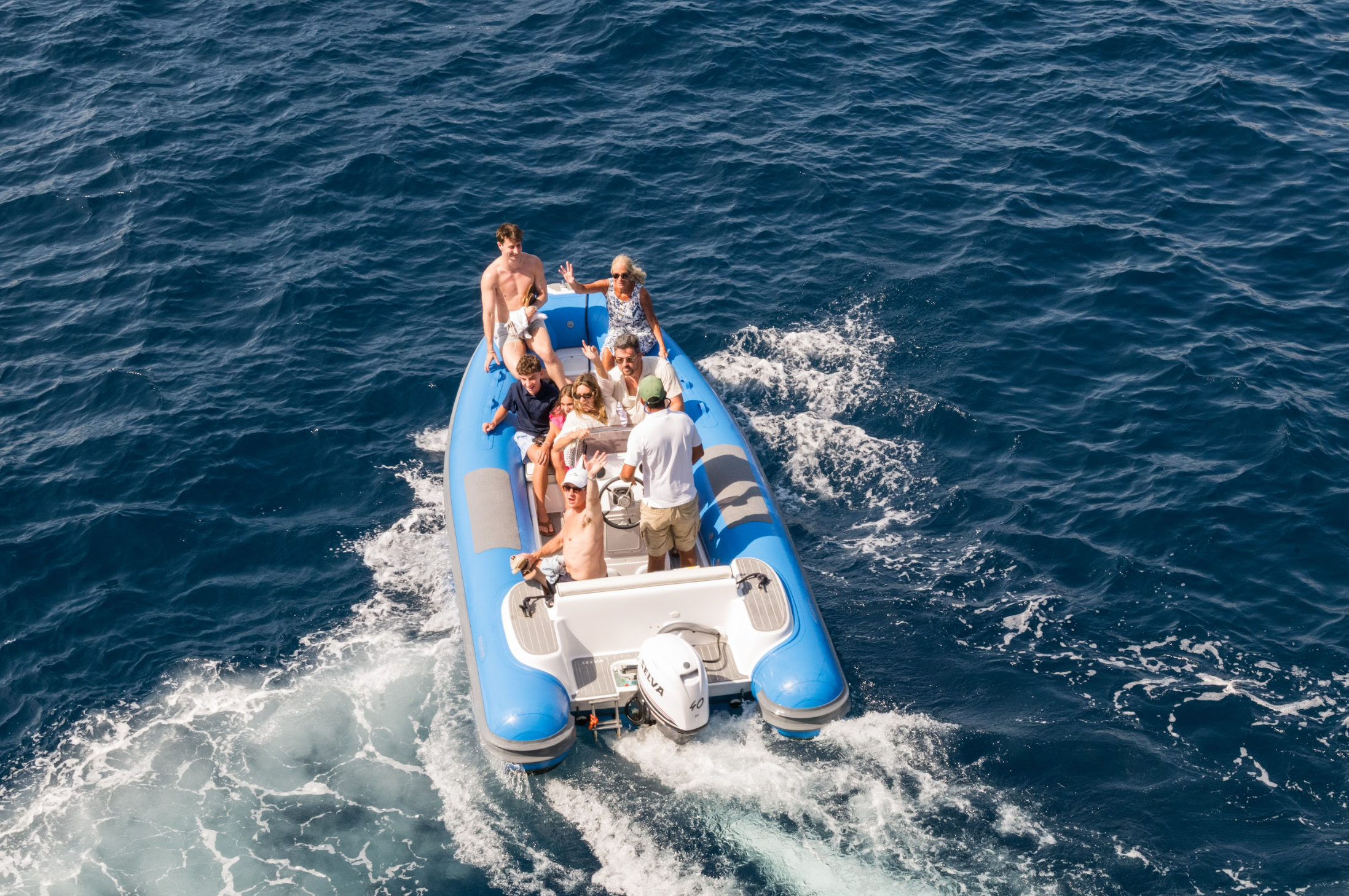 Wedding guests traveling across the Mediterranean by boat during an Italy destination wedding weekend.