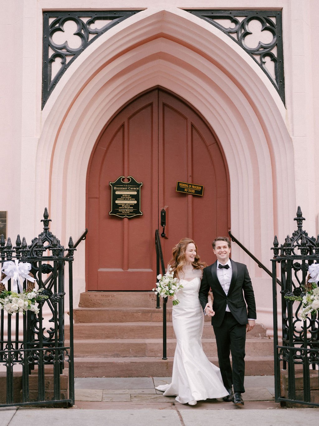 Bride and groom leaving The Huguenot Church in Charleston during an East Coast destination wedding weekend.