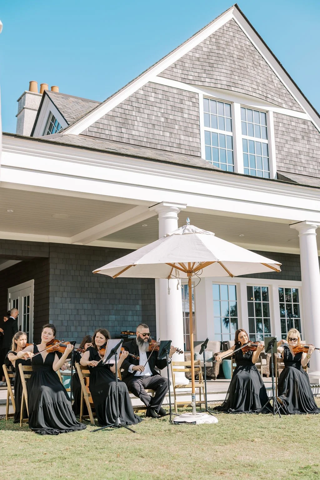 Live string ensemble performing outdoors as guests arrive for a Kiawah Island wedding ceremony.