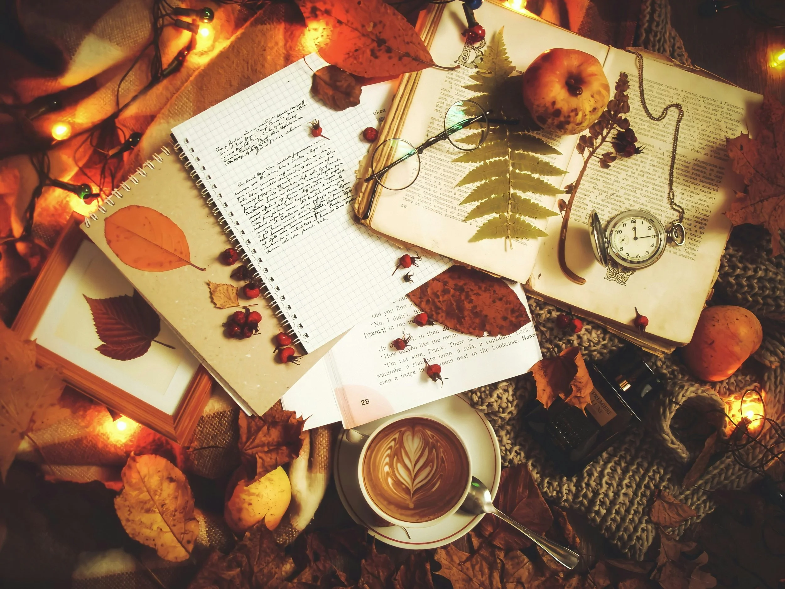 Journal on a fall-themed table reminding writers to stay motivated and make time for writing during the holidays