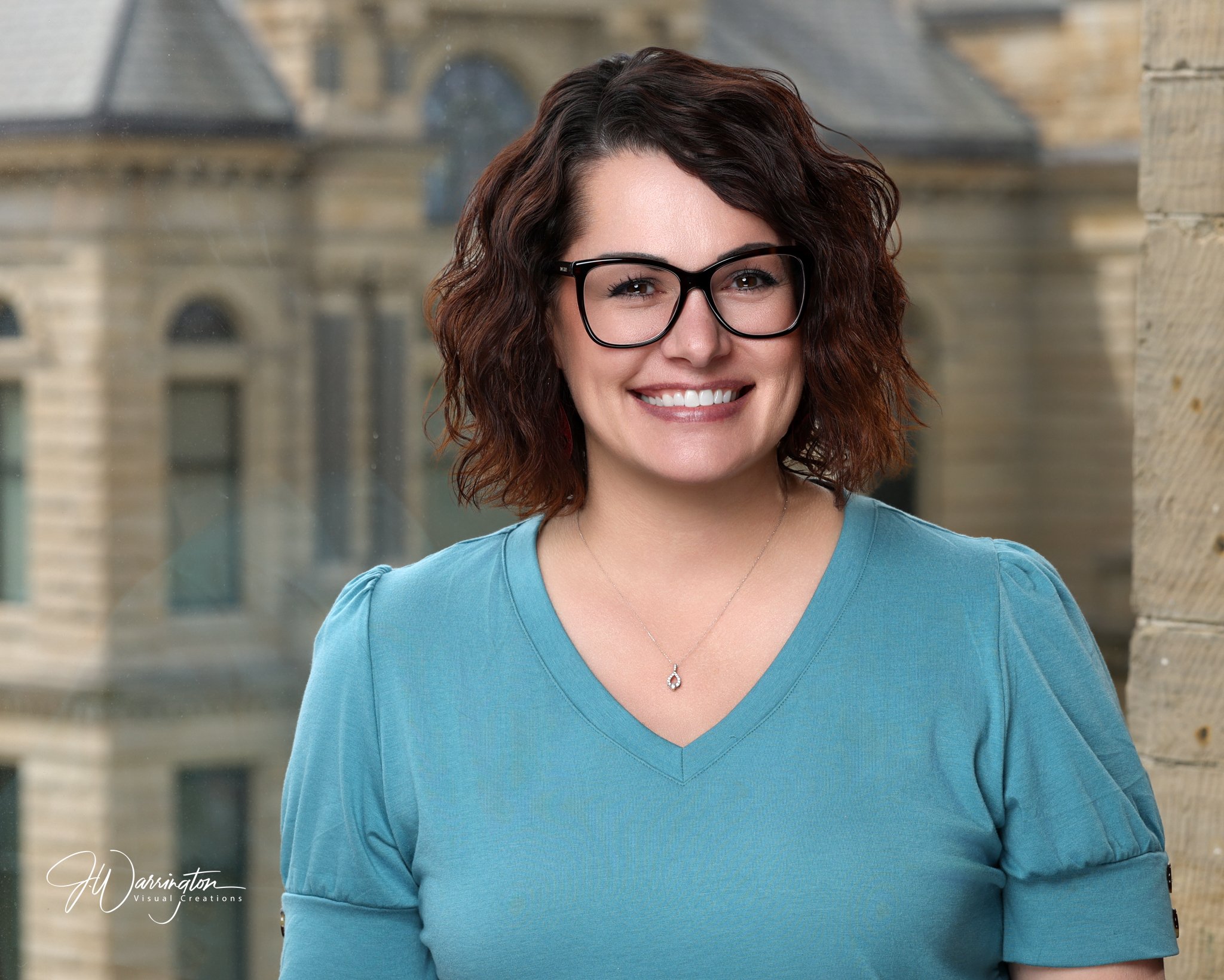 A young woman in a teal blouse smiling by findlay ohio photographer
