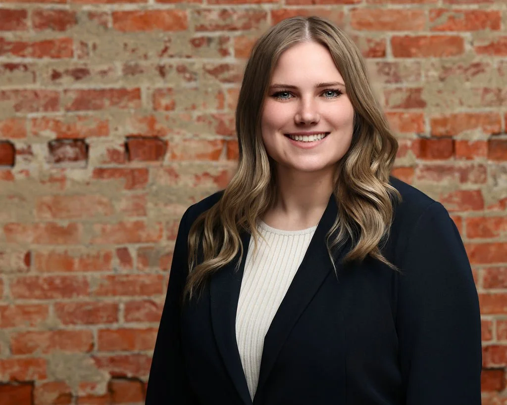 Female corporate headshot with exposed brick backdrop captured by northwest ohio photographer