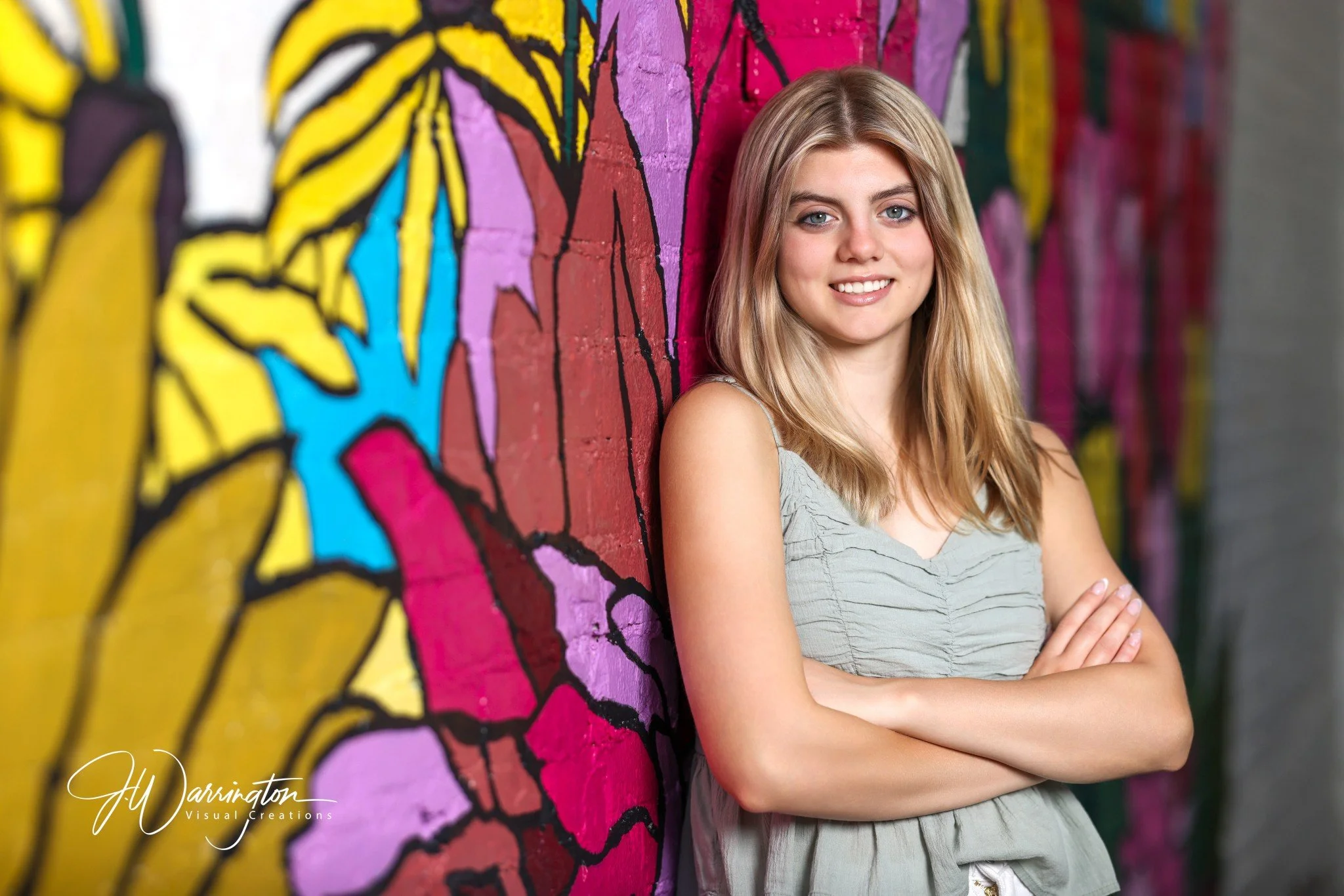 Pretty blonde highschool senior taking photos on colorful backdrop northwest ohio photographer