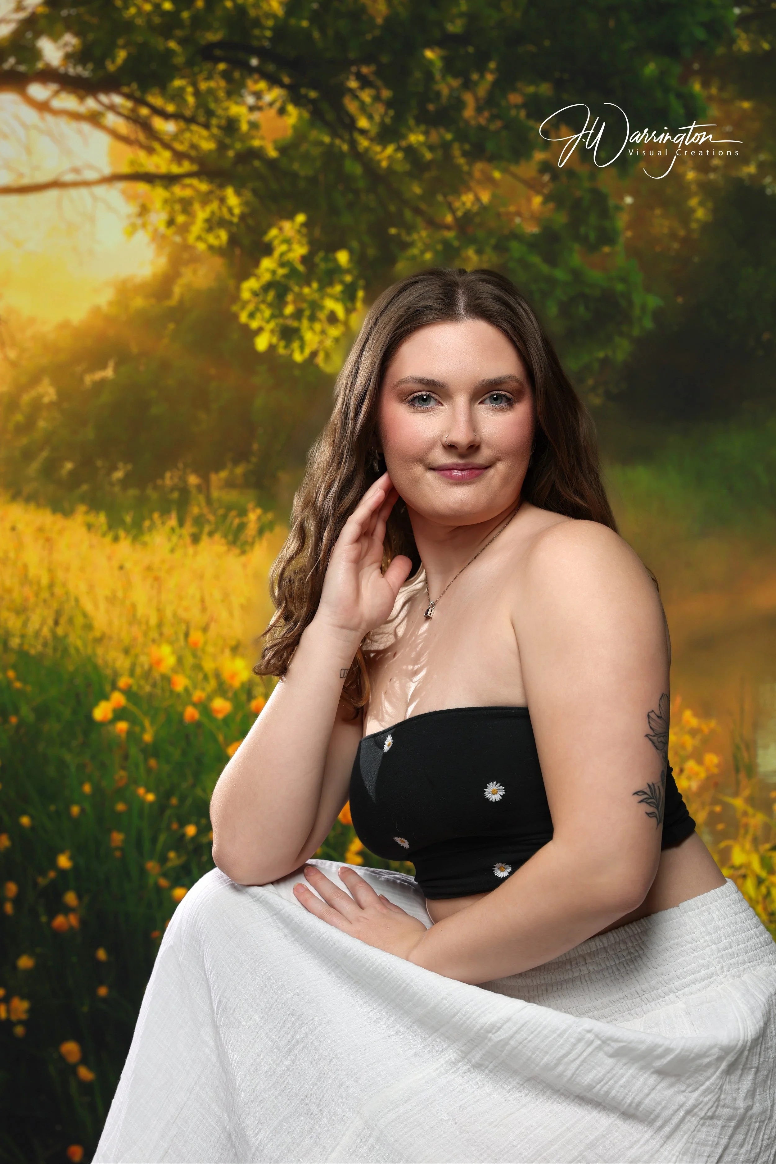 Female senior smiling in front of a golden meadow backdrop.