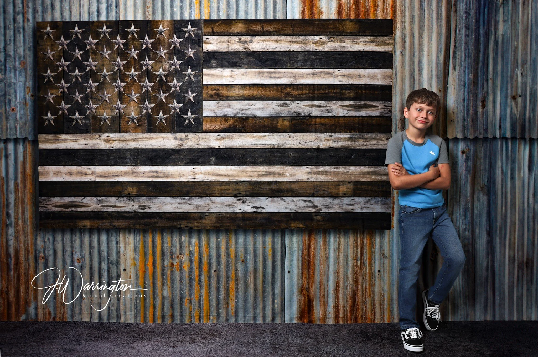young boy wearing blue shirt with american flag background