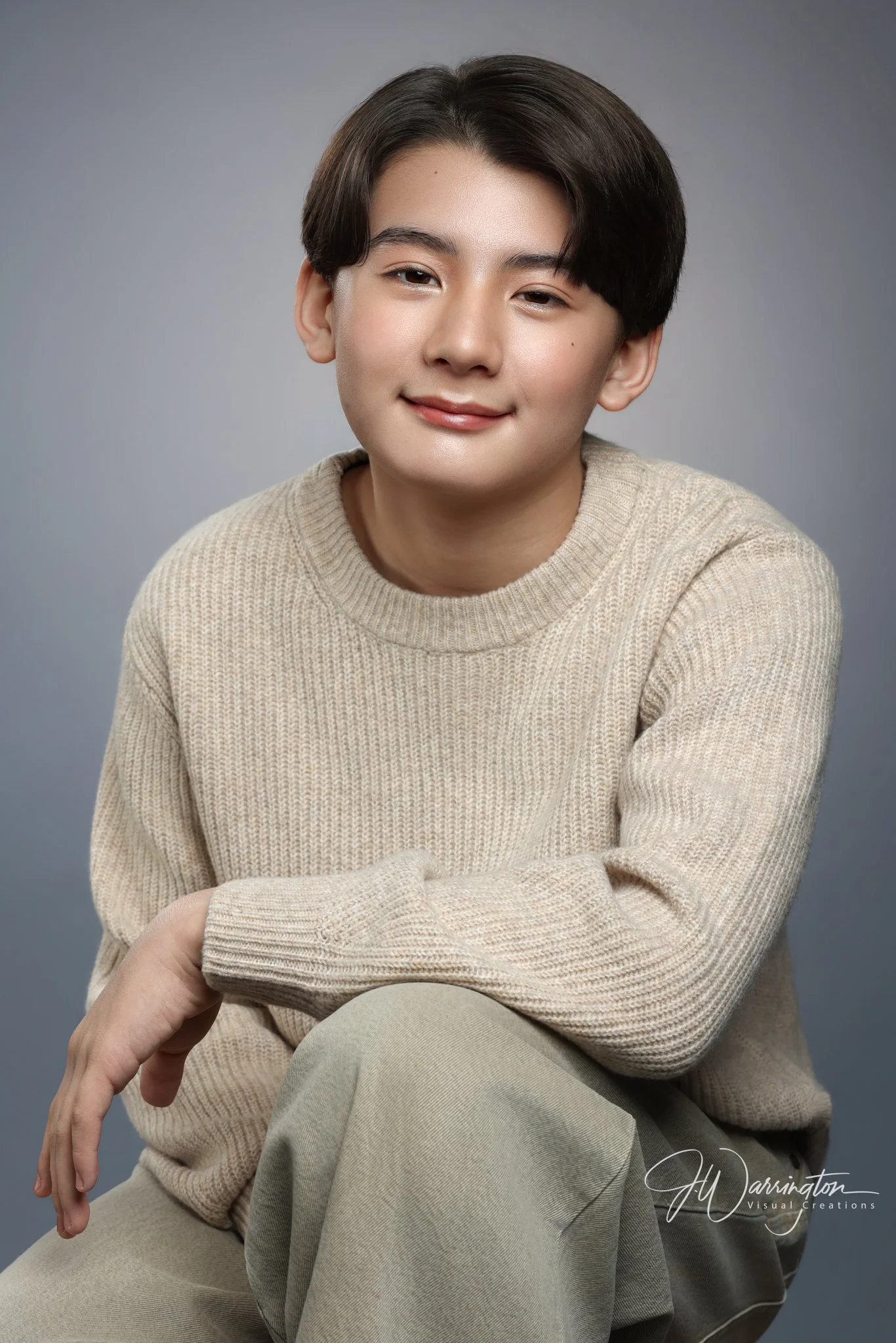 Studio portrait of a smiling teenage boy wearing a beige sweater, captured by northwest ohio photographer 