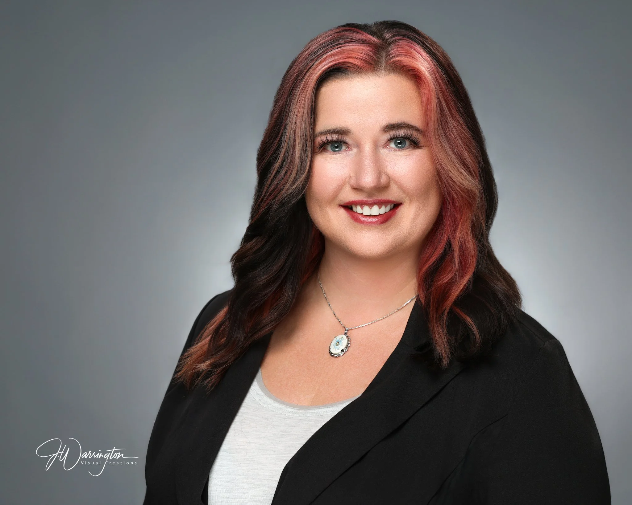 A young woman in a black blazer and white top smiling by findlay ohio photographer