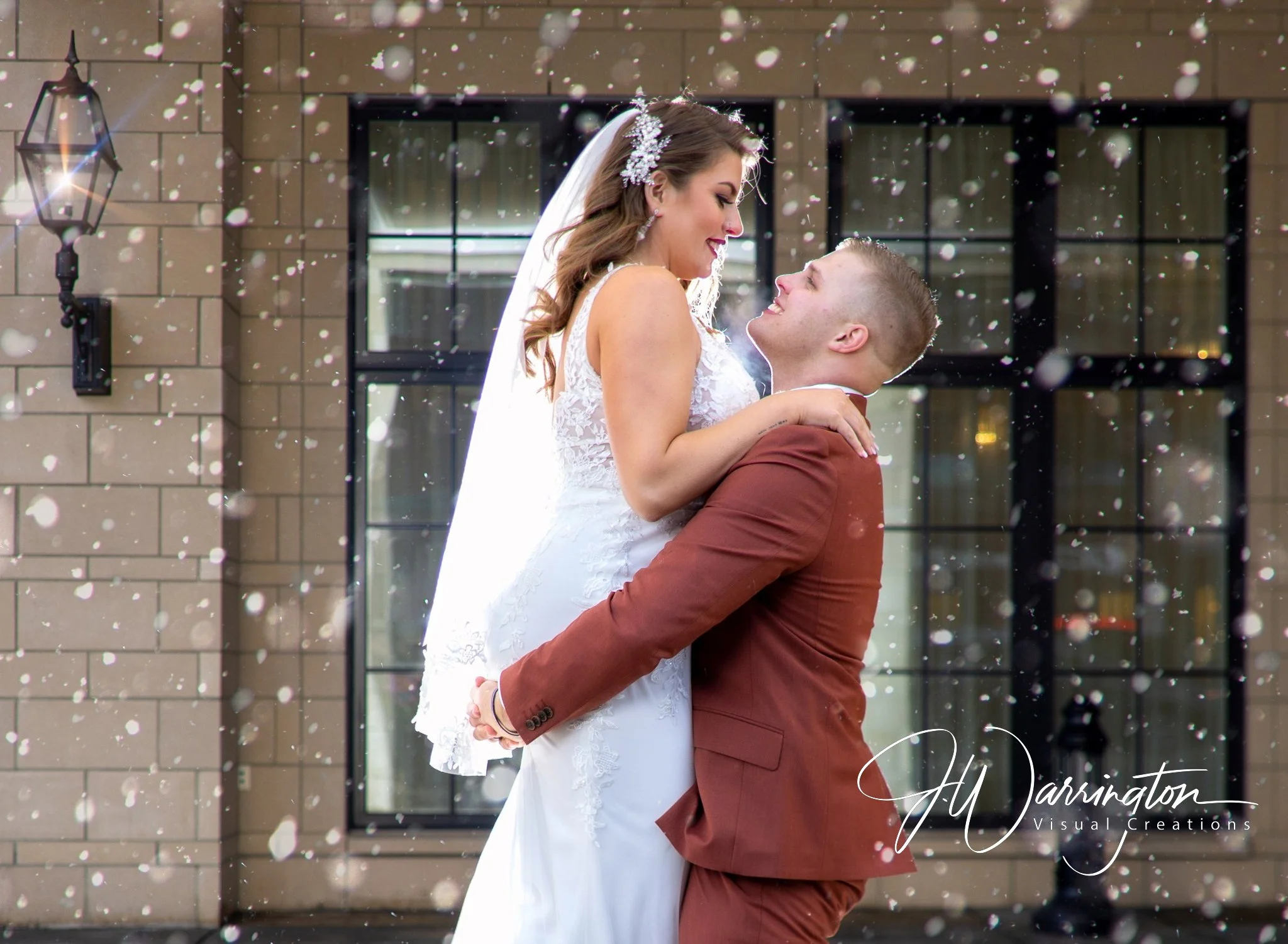 Newly married bride and groom embracing and sharing a kiss under the snow captured by northwest ohio photographer