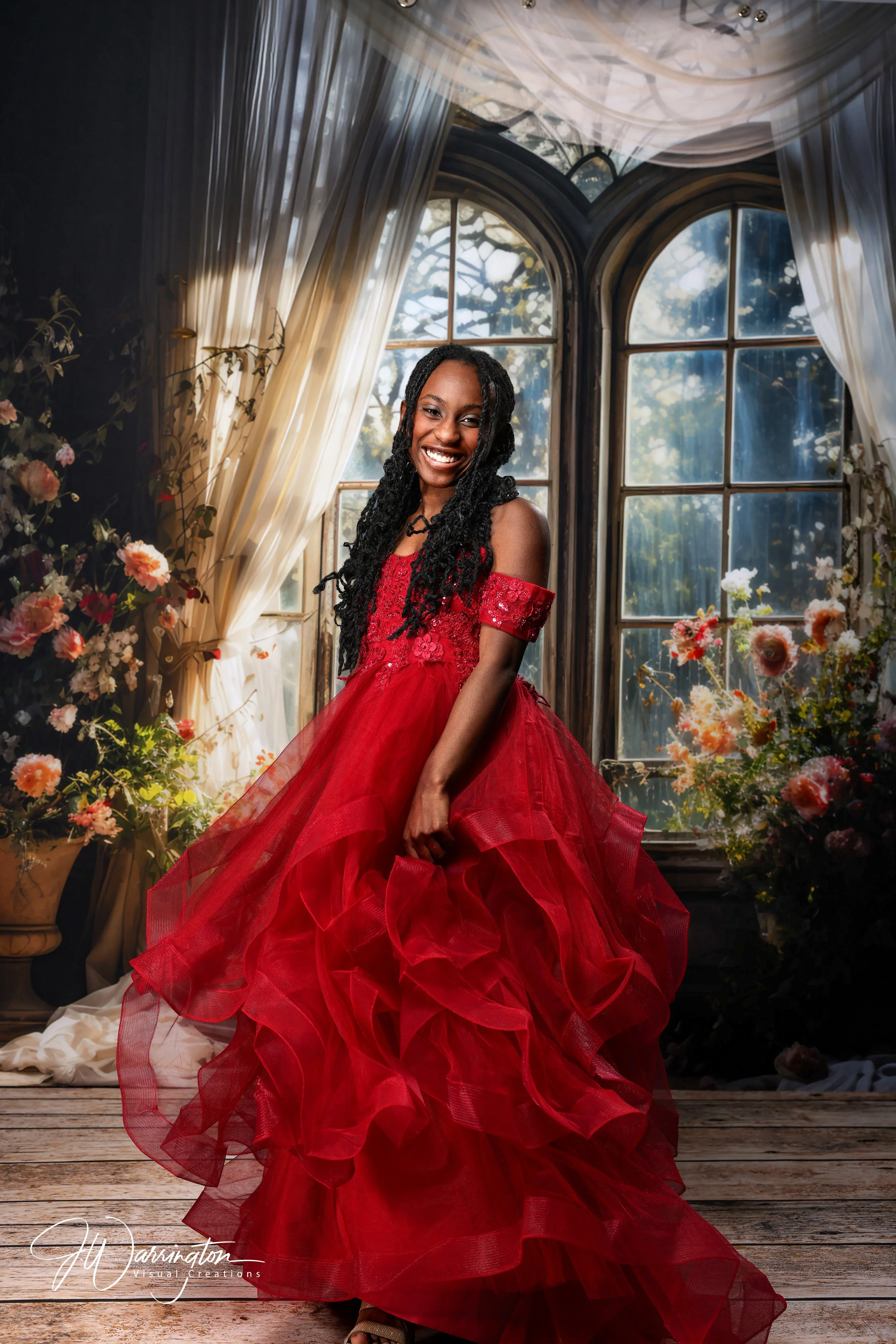 Female senior flowing red dress against floral spring window.