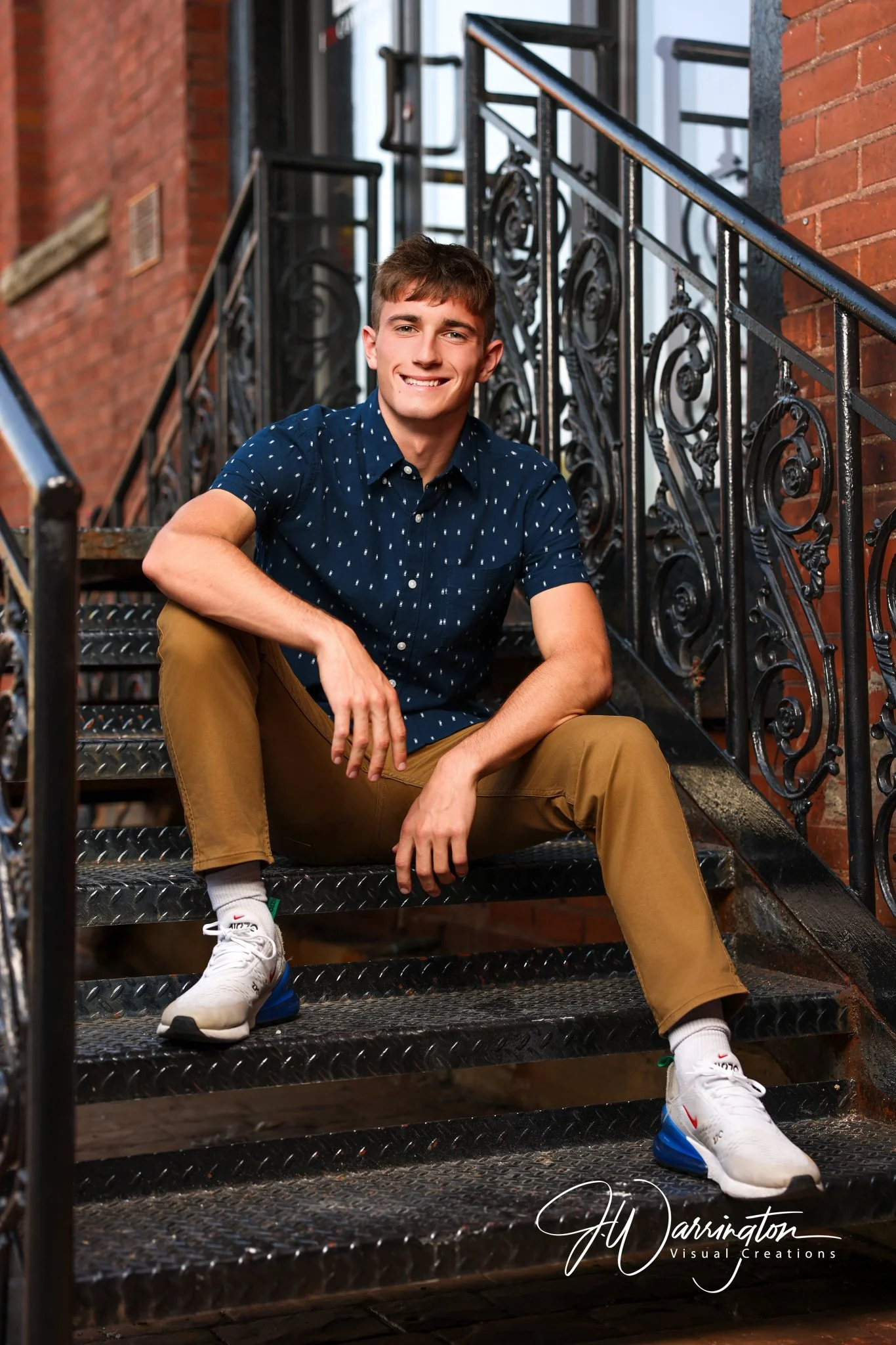 Male senior smiling, sitting on steps in Downtown FIndlay.
