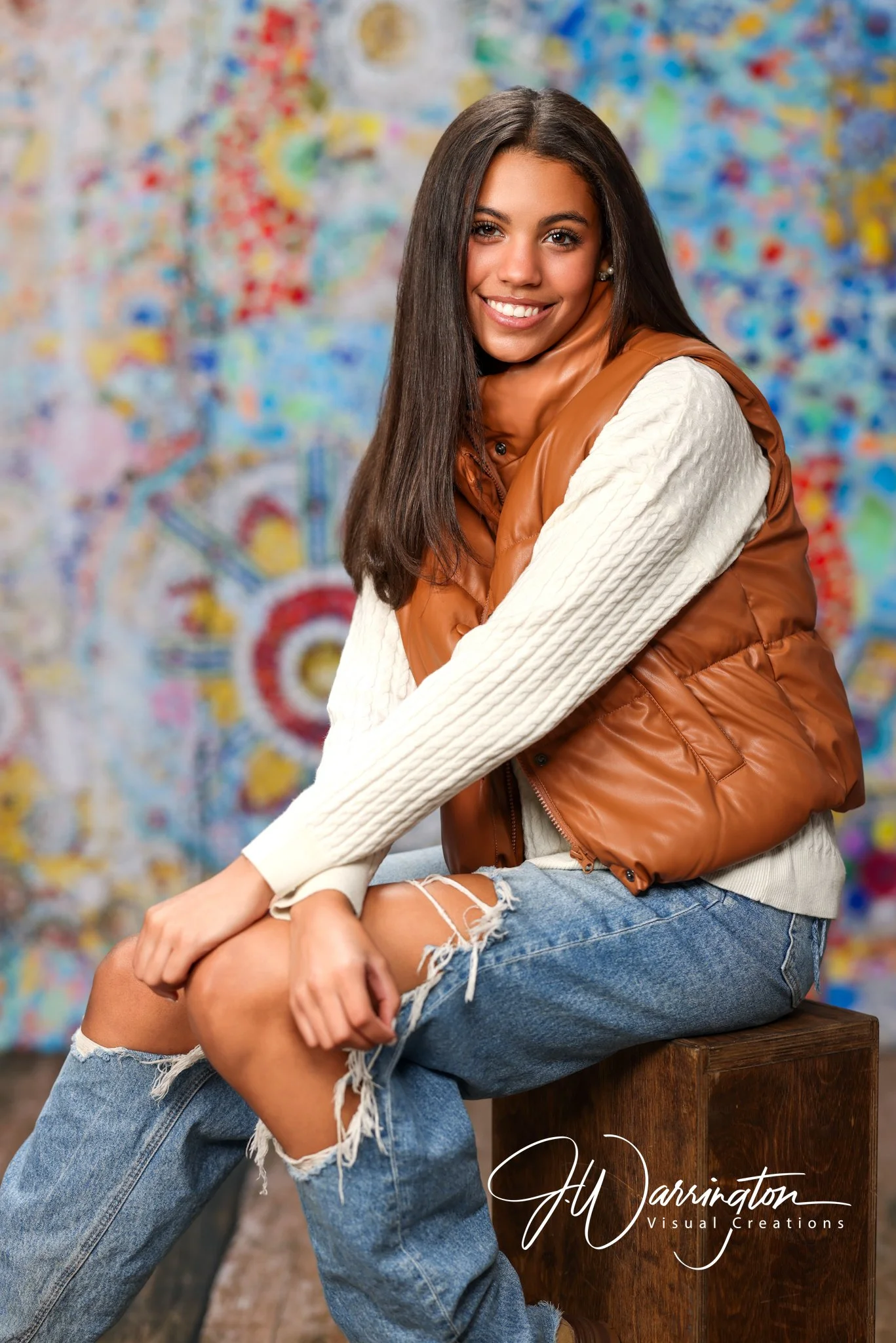 High school senior girl posing against a colorful abstract backdrop during a creative studio portrait session