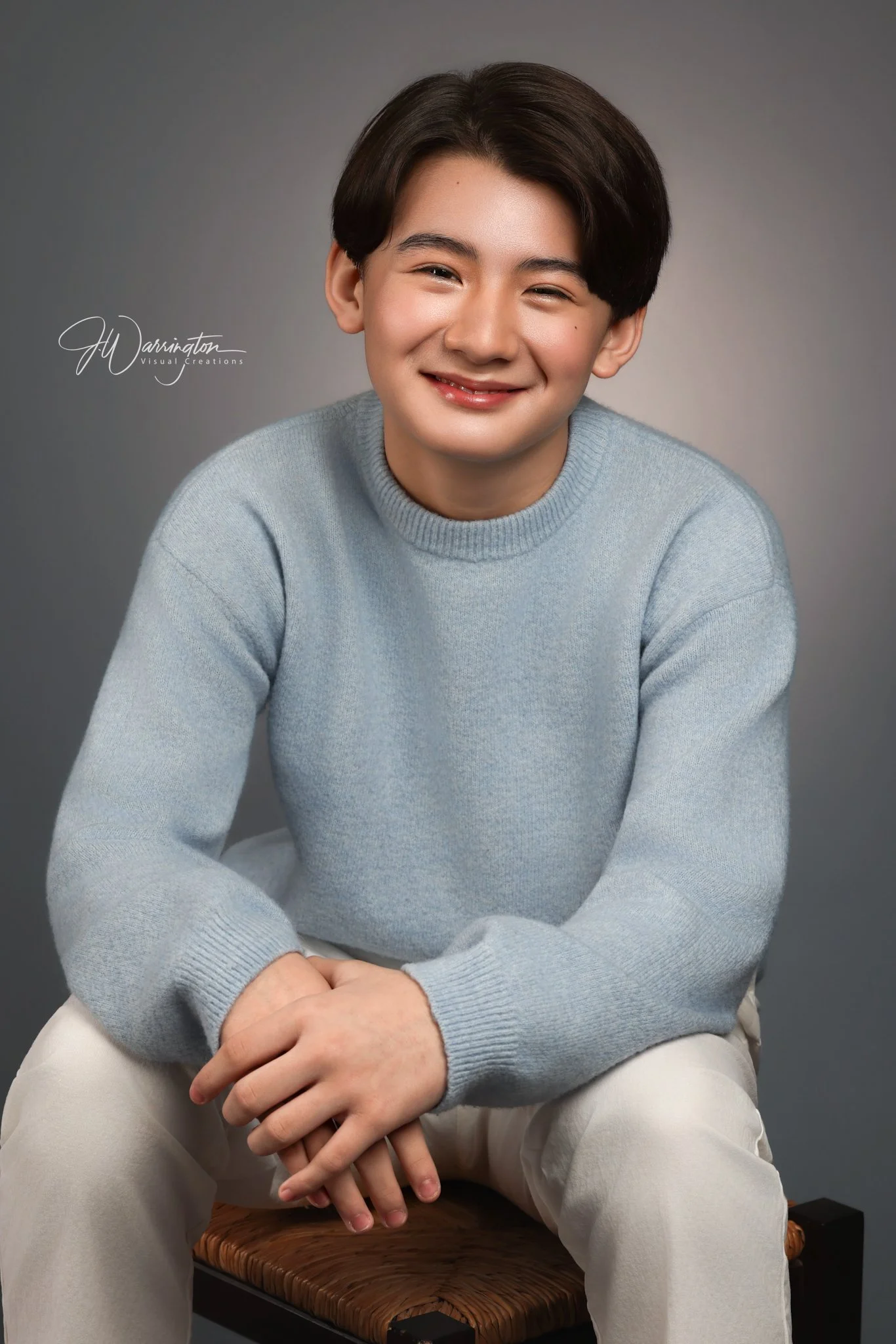 Studio portrait of a smiling teenage boy wearing a light blue sweater, captured by northwest ohio photographer 