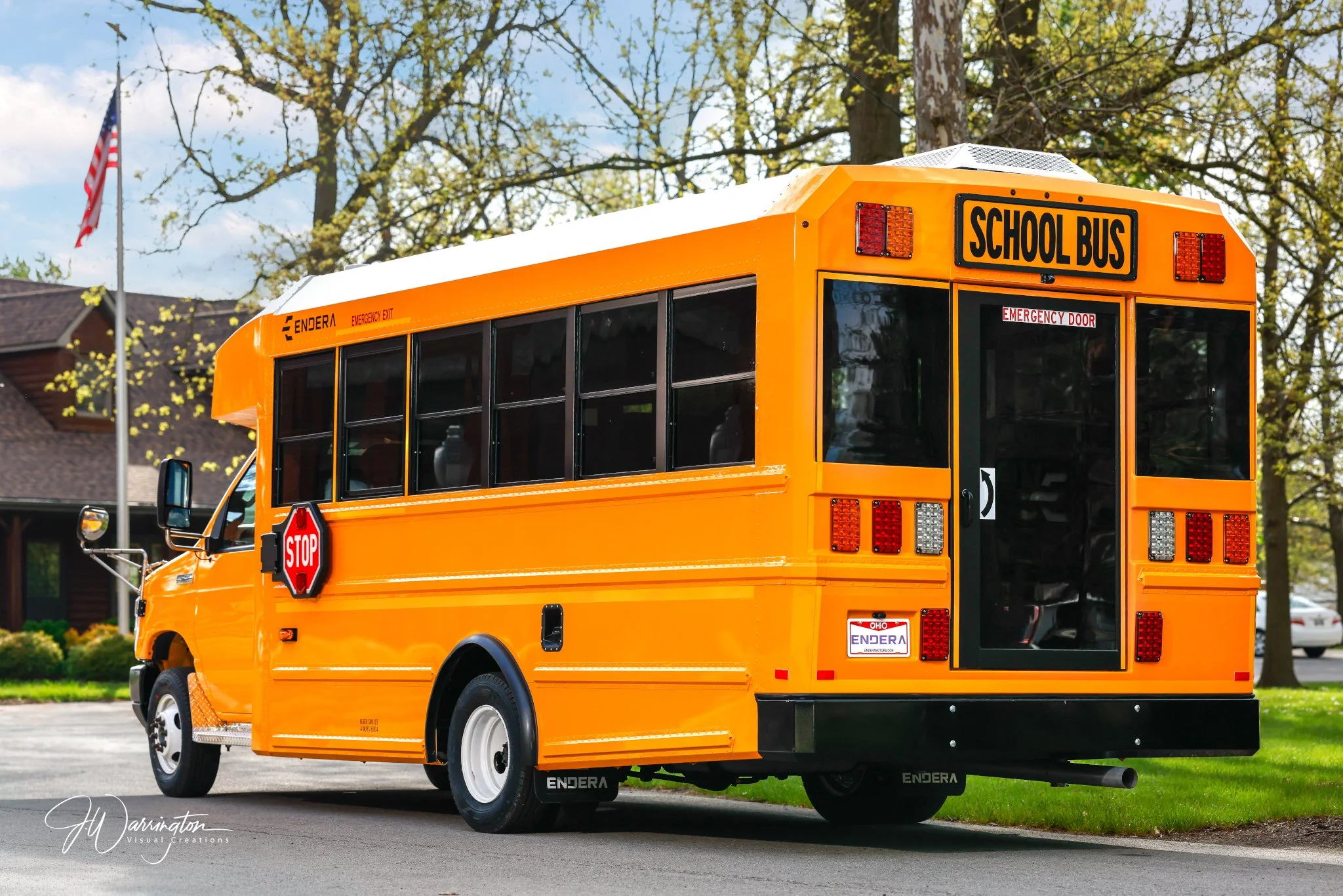 Yellow school bus parked in front of a commercial building on a bright day captured by  Northwest Ohio photographer