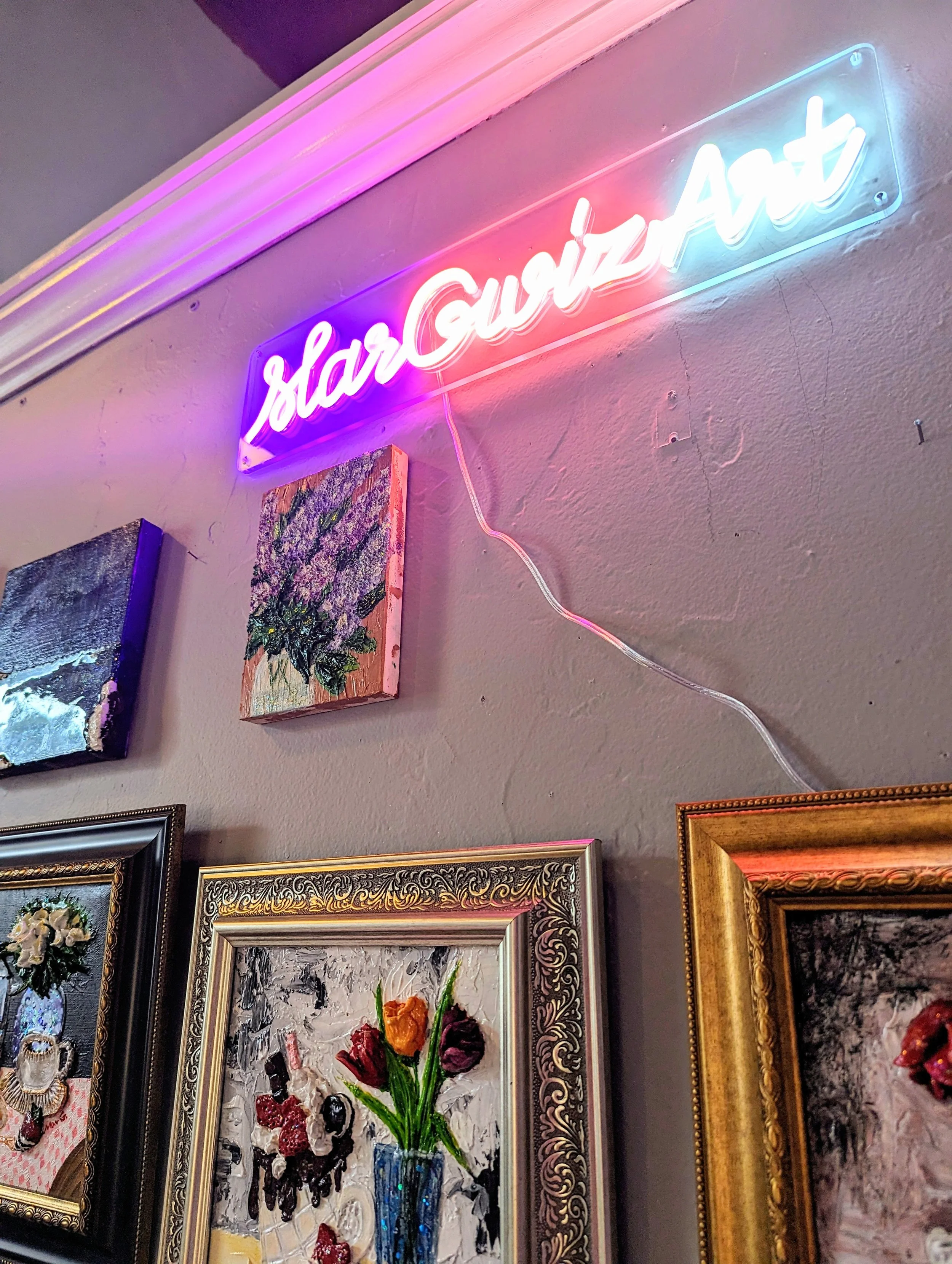Photo of neon sign of Margwizart's studio.