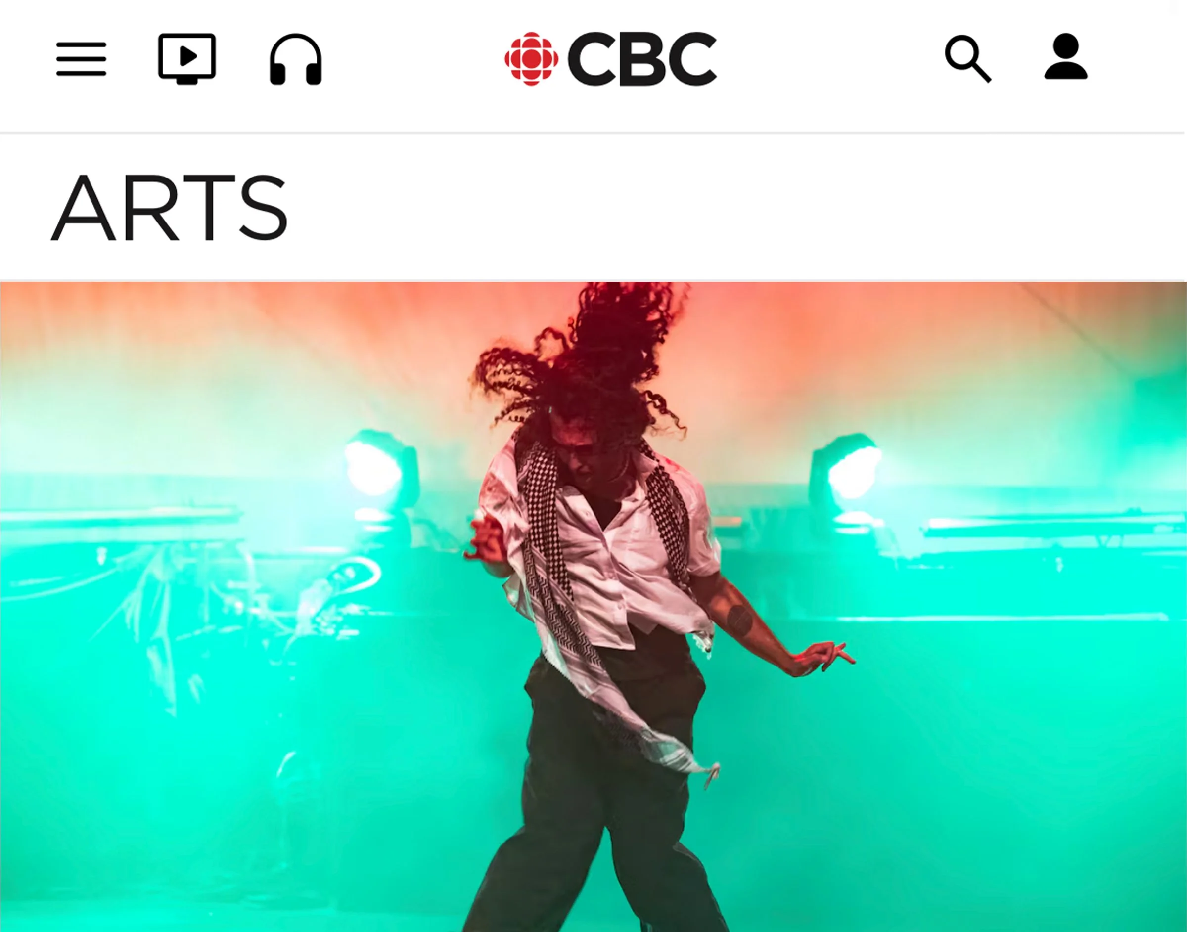 A performer dancing on stage with colorful background lights and smoke effects.