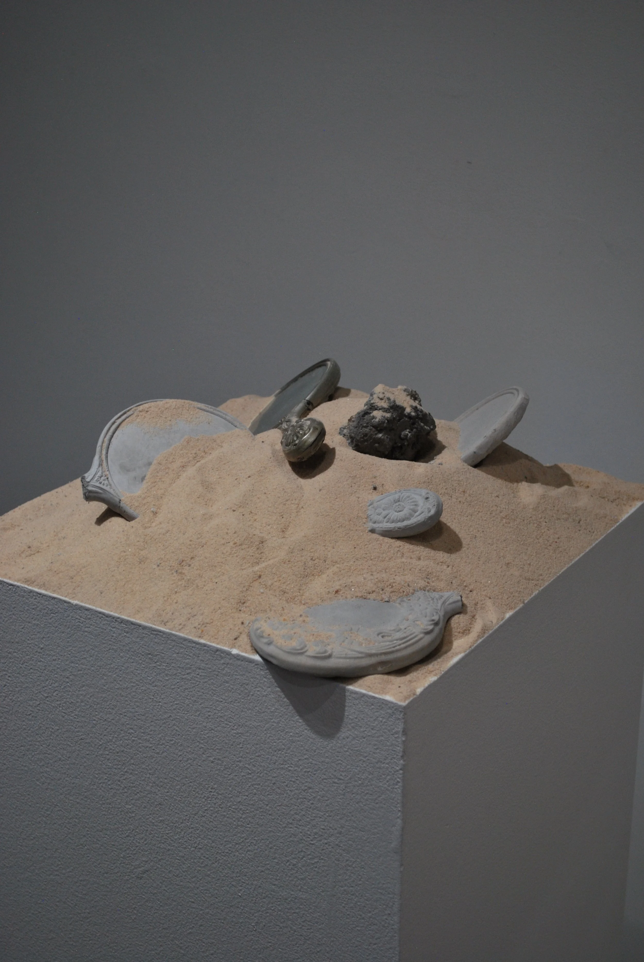 "Damnatio," 2024, Cast concrete, sand, and found object. 