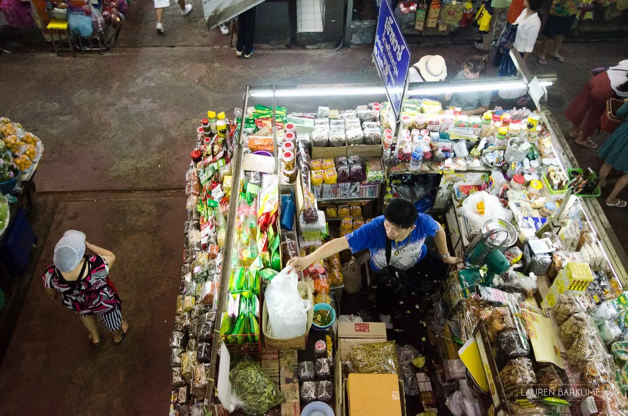 A shopkeeper grabs a packet in a tightly packed shop in the famous Warorot Market in Chiang Mai