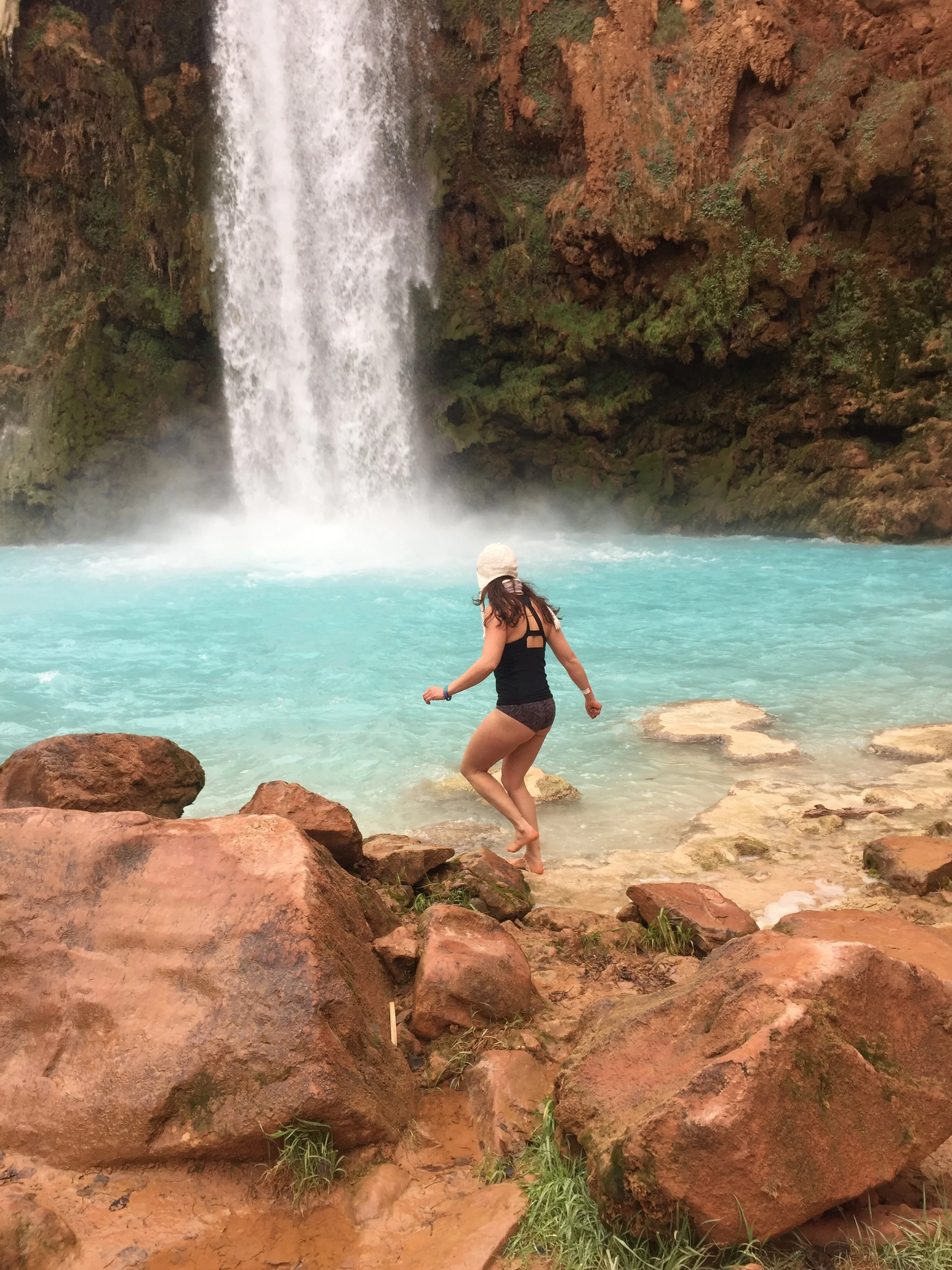 Image of Jessica Ghantous with back toward camera and in front of waterfall in Havasupai.